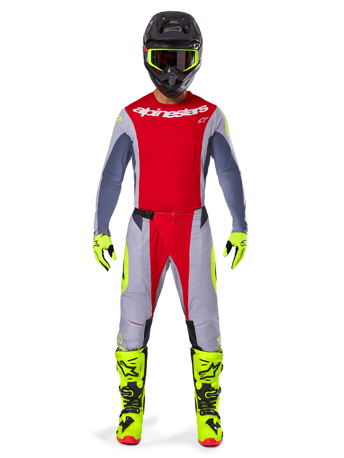 Pilota di motocross con pantaloni Alpinestars Techstar Melt 2025 in rosso brillante e grigio, caratterizzati da pannelli rossi vivaci e accenti giallo fluorescente, abbinati a maglia coordinata, casco nero con occhiali giallo fluorescente e stivali e guanti giallo brillante, completo coordinato per gare di motocross professionale.