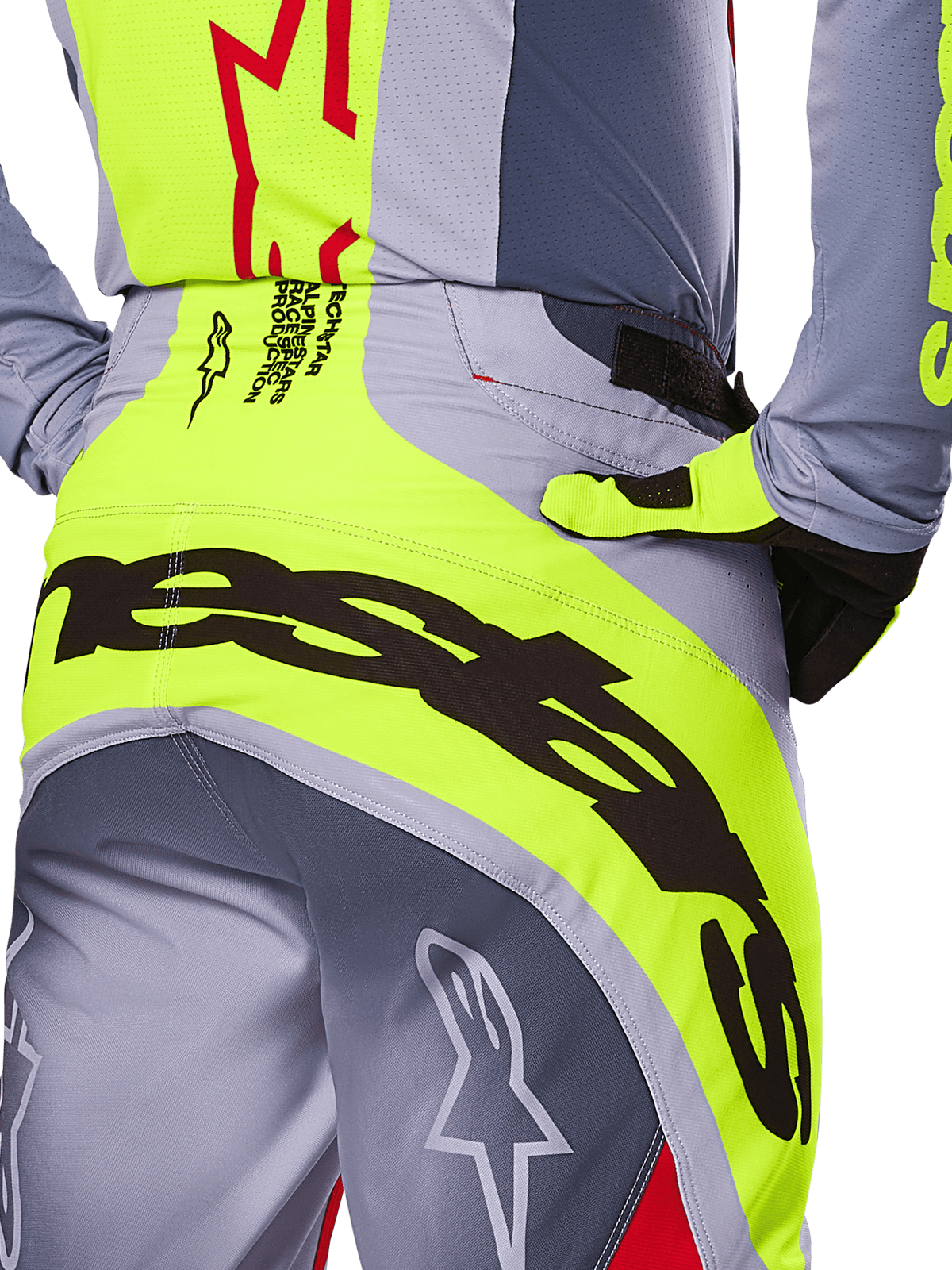 Alpinestars 2025 Techstar Melt Pants, primo piano della zona della seduta e della vita, design grigio e giallo neon con grande branding nero, con loghi a stella e scritte race-spec, abbigliamento da motocross ad alte prestazioni