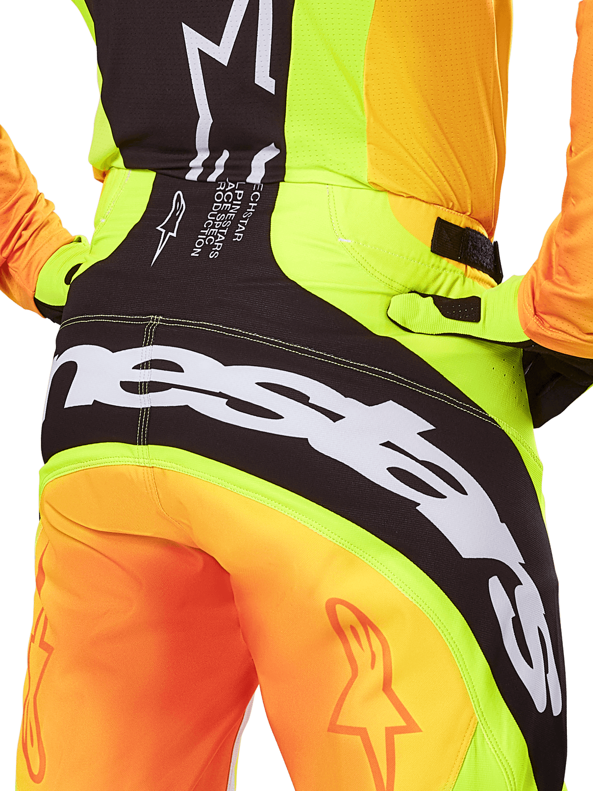 Alpinestars 2025 Techstar Melt Pants, pantaloni da motocross, vista posteriore ravvicinata, giallo neon e arancione con pannelli neri, grande marchio Alpinestars bianco sulla seduta, abbigliamento tecnico per fuoristrada