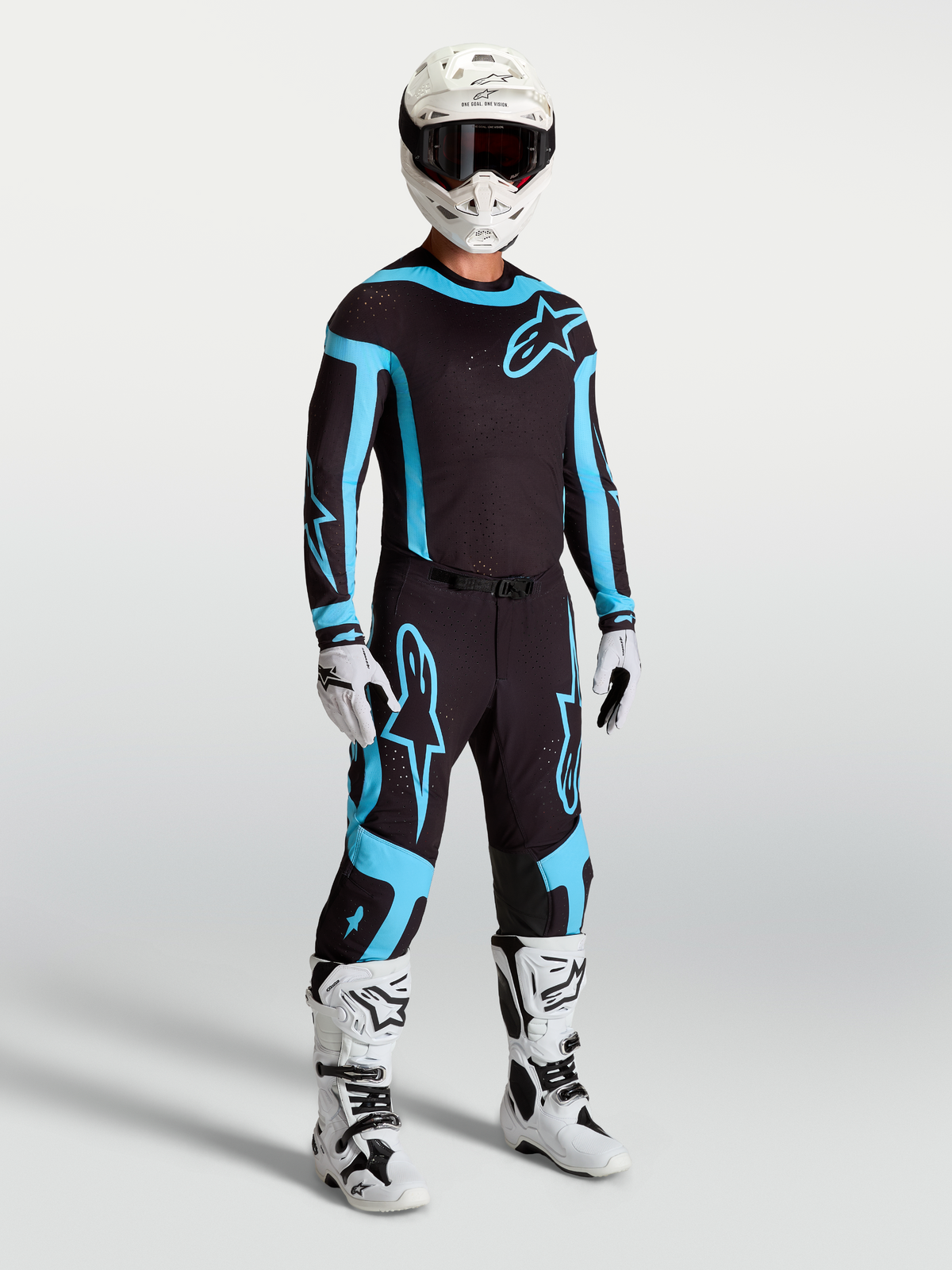 Alpinestars pantaloni Supertech Vesta, abbigliamento motocross racing da uomo, nero e turchese, indossati con stivali e casco bianchi, vestibilità atletica