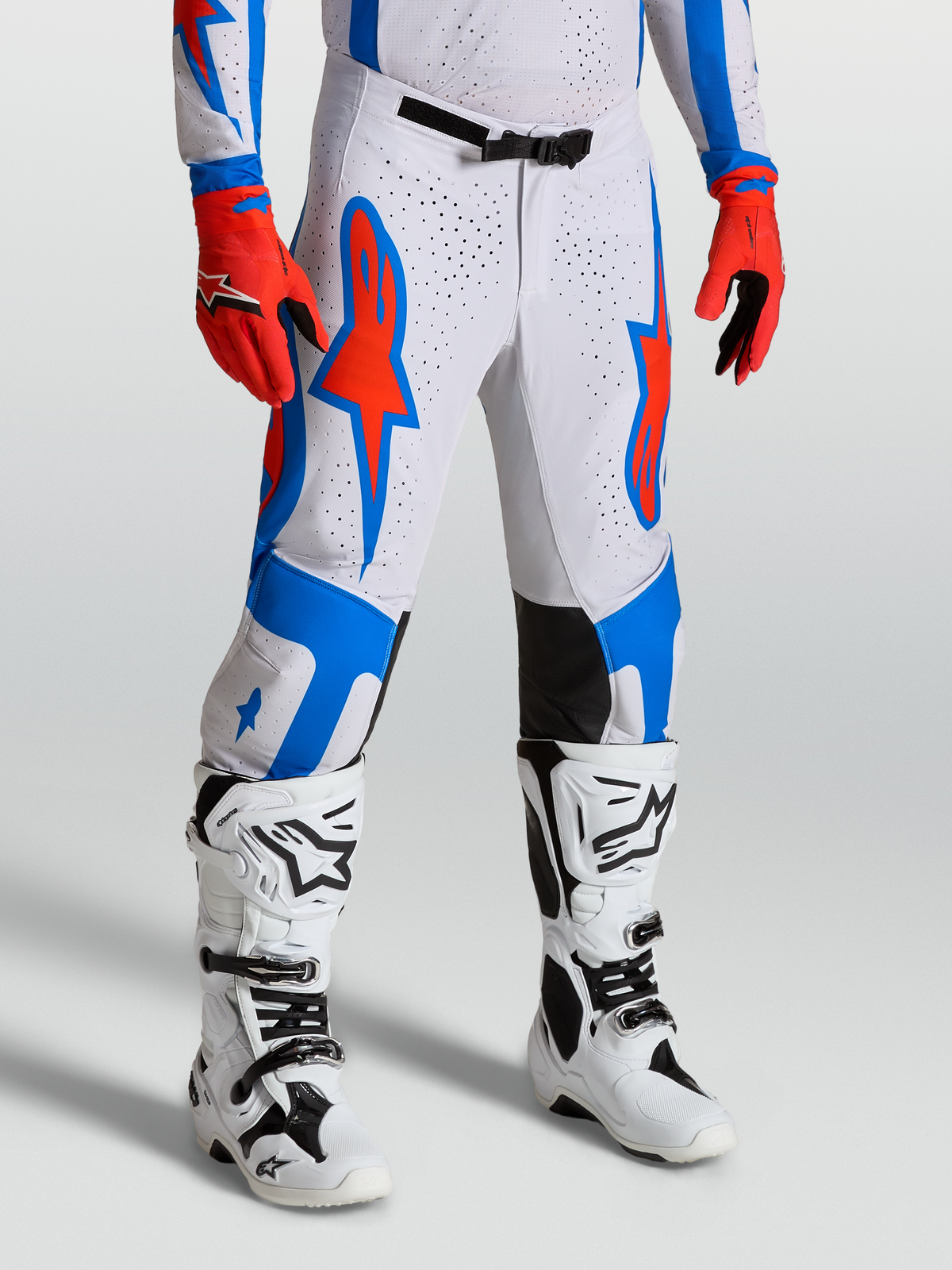 Alpinestars Pantaloni Supertech Vesta, pantaloni da motocross bianchi e rossi con grafiche blu, vestibilità atletica da gara su modello, abbigliamento off-road pro level