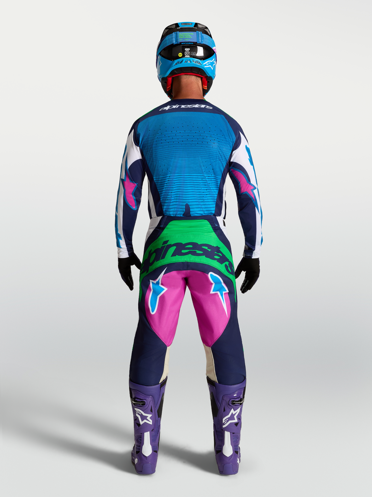 Alpinestars Techstar Maven Gear Set e Pantaloni, completo da motocross da uomo, blu e rosa, vista posteriore su modello, abbigliamento tecnico per racing fuoristrada e MX