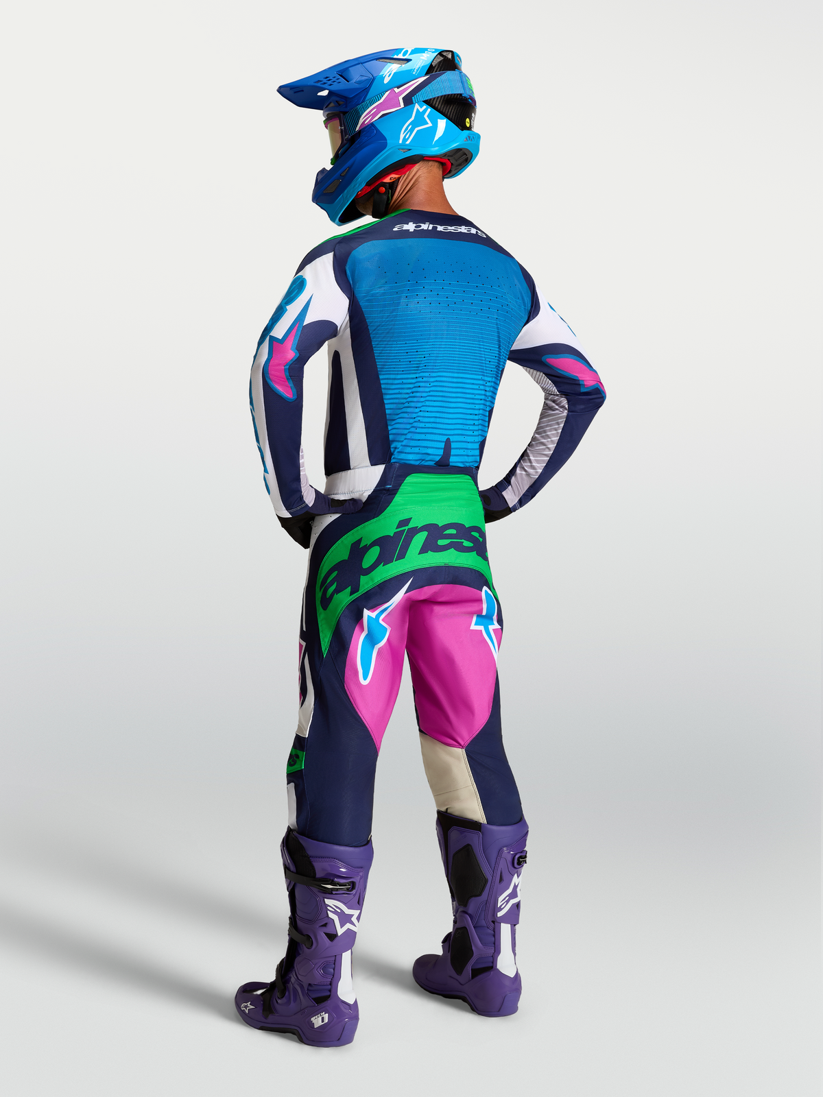 Alpinestars Techstar Maven Gear Set e Pantaloni, completo da motocross blu e rosa con accenti verde fluo, vista posteriore.