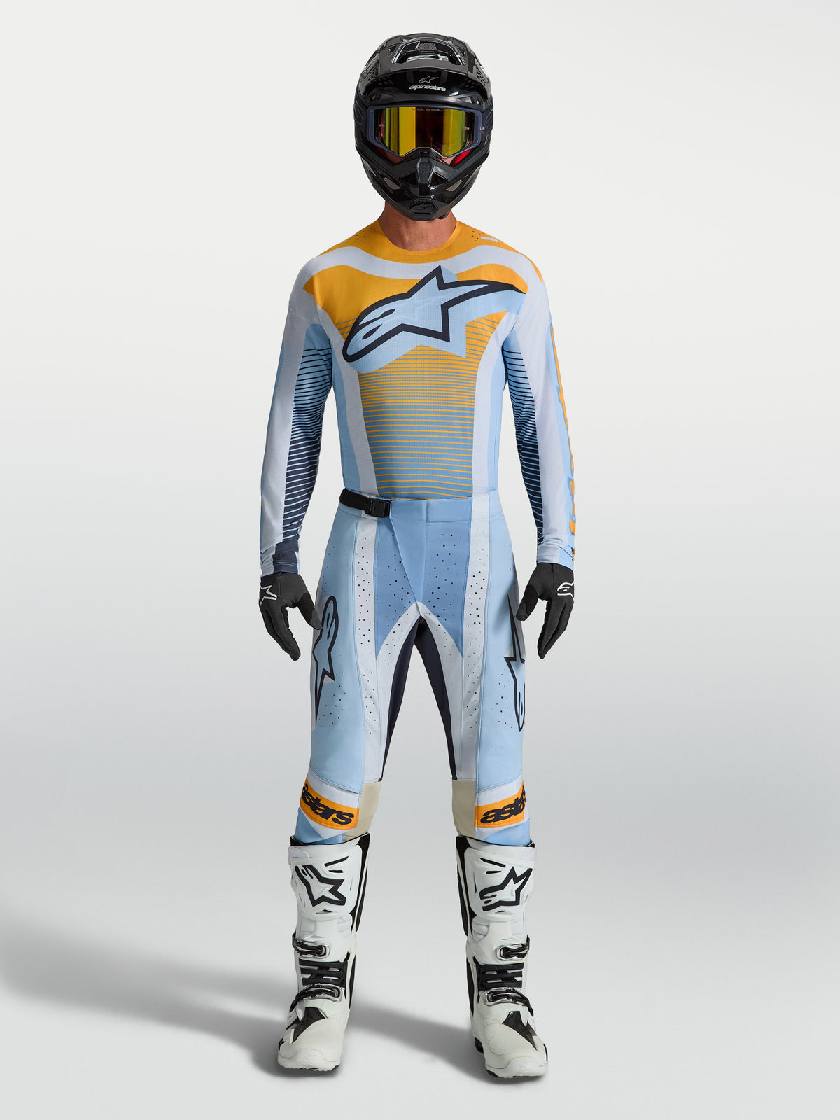 Alpinestars Pantaloni Techstar Maven, pantaloni motocross da uomo, blu e arancione, vestibilità race e zone elasticizzate, indossati con kit completo da fuoristrada.