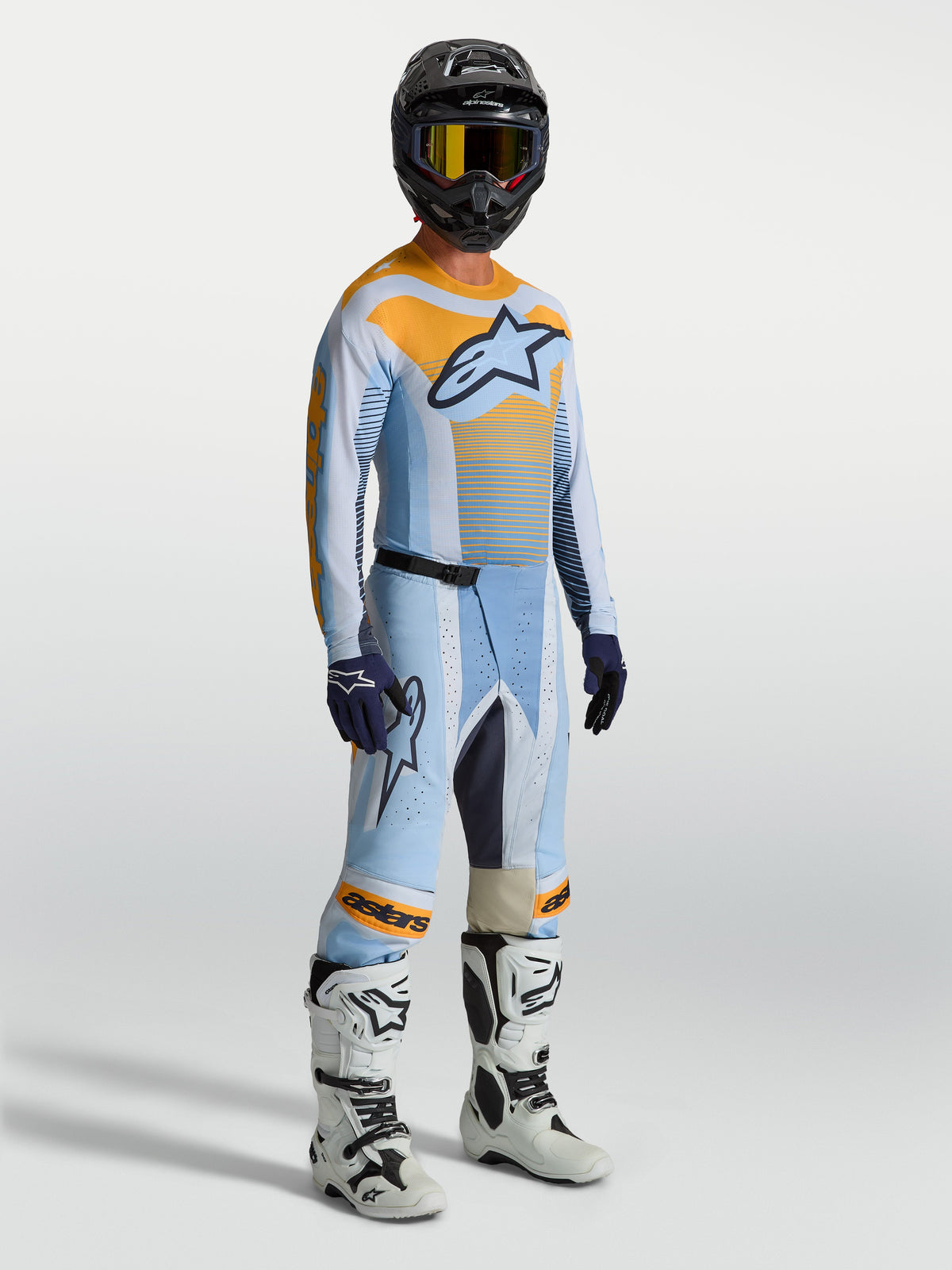 Alpinestars pantaloni Techstar Maven, pantaloni da motocross da uomo, blu e arancione, vestibilità racing, indossati da un pilota.
