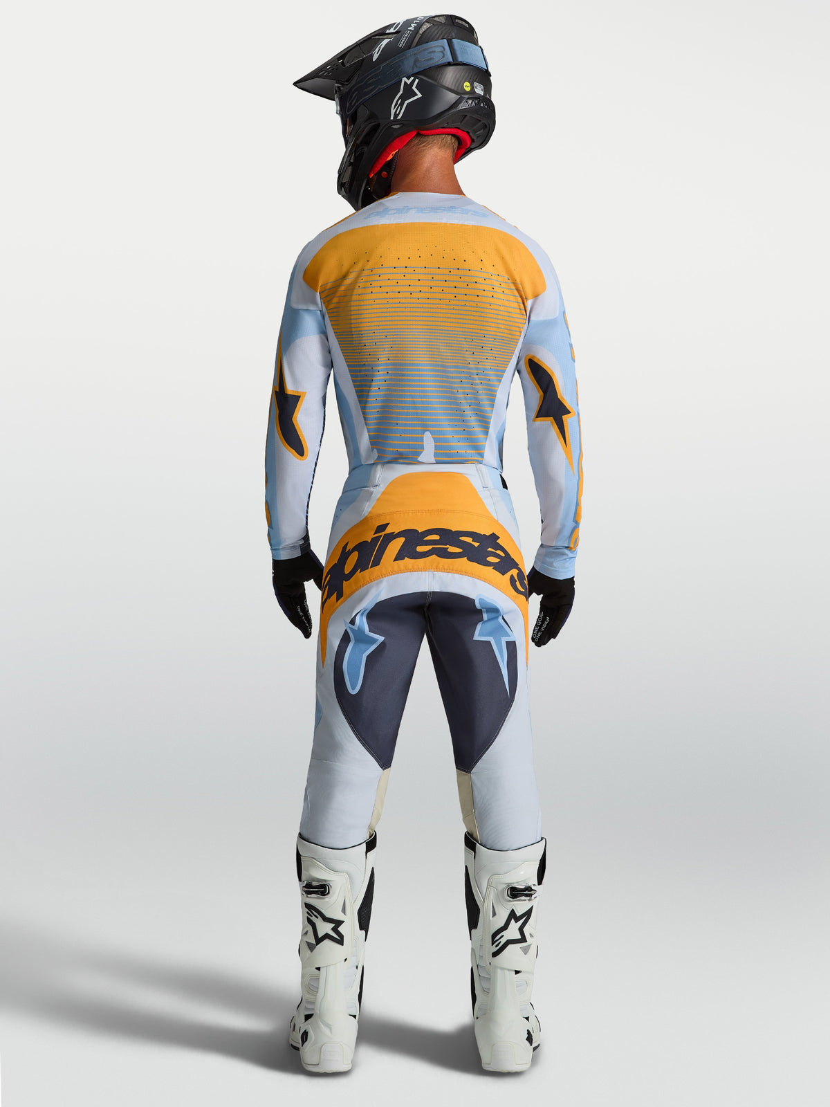 Alpinestars Pantaloni Techstar Maven, pantaloni da motocross da uomo, blu polvere e arancione, vista posteriore su modello con sedile rinforzato e vestibilità race ergonomica per fuoristrada