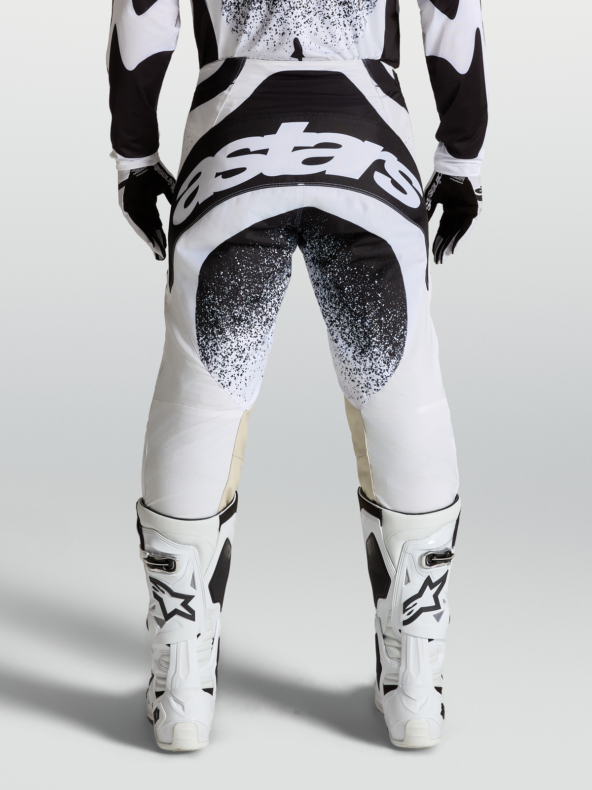 Alpinestars Pantaloni Techstar Swan, pantaloni da motocross neri e bianchi, vista posteriore con grafica logo Astars, costruzione Babel del ginocchio, abbigliamento racing fuoristrada professionale