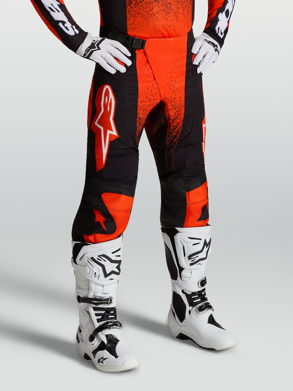 Alpinestars Pantaloni Techstar Swan, pantaloni da motocross da uomo, rosso cardinale e nero, indossati con stivali bianchi, pannelli ripstop elasticizzati per corse fuoristrada ed enduro