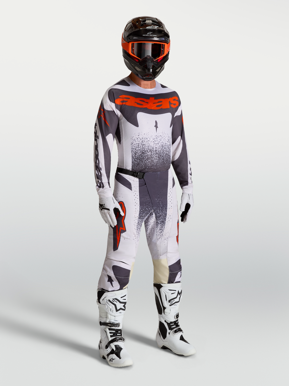 Alpinestars Techstar Swan, completo da motocross per uomo con maglia e pantaloni grigio chiaro, grigio scuro e rosso fluo, stivali bianchi e casco coordinato, ideale per gare off-road e motocross.