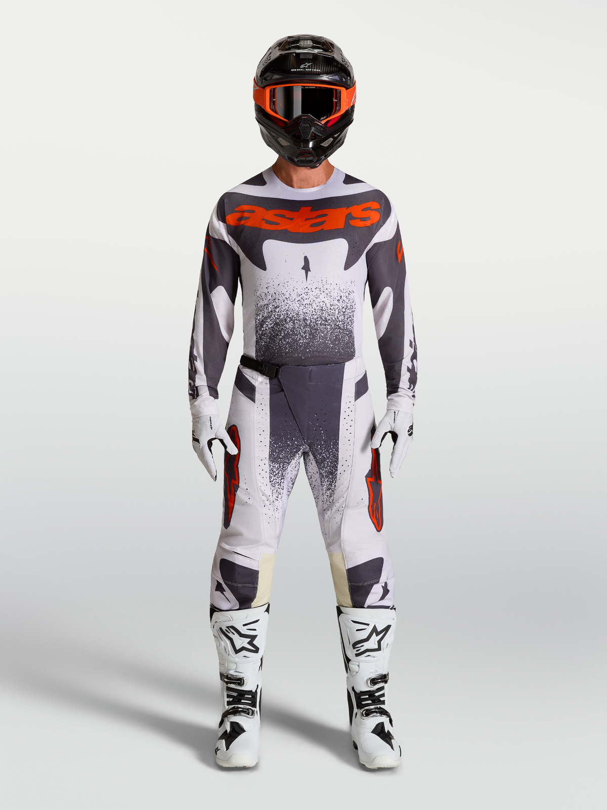 Alpinestars Pantaloni Techstar Swan, completo da motocross da uomo, lilla chiaro, grigio scuro e rosso fluo, con maglia coordinata e stivali bianchi, abbigliamento tecnico per fuoristrada.