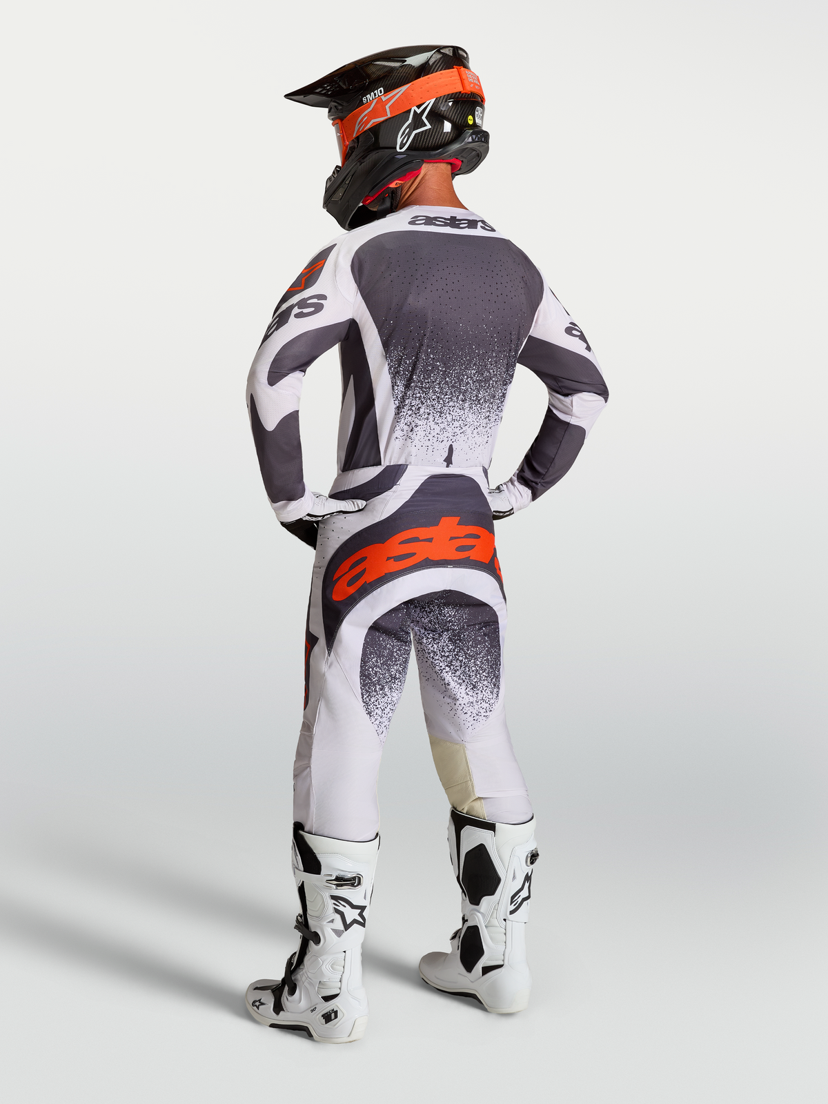 Alpinestars maglia e pantaloni Techstar Swan, completo motocross uomo grigio e bianco con rosso fluo, vista posteriore.