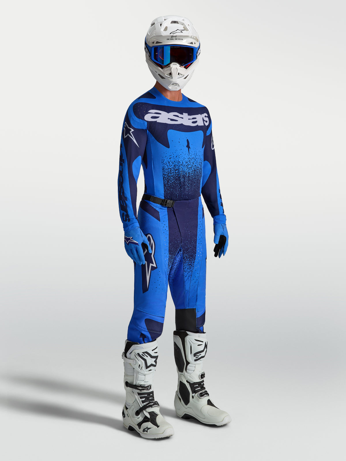 Alpinestars Pantaloni Techstar Swan, pantaloni motocross da uomo blu e navy, con maglia coordinata e stivali bianchi.