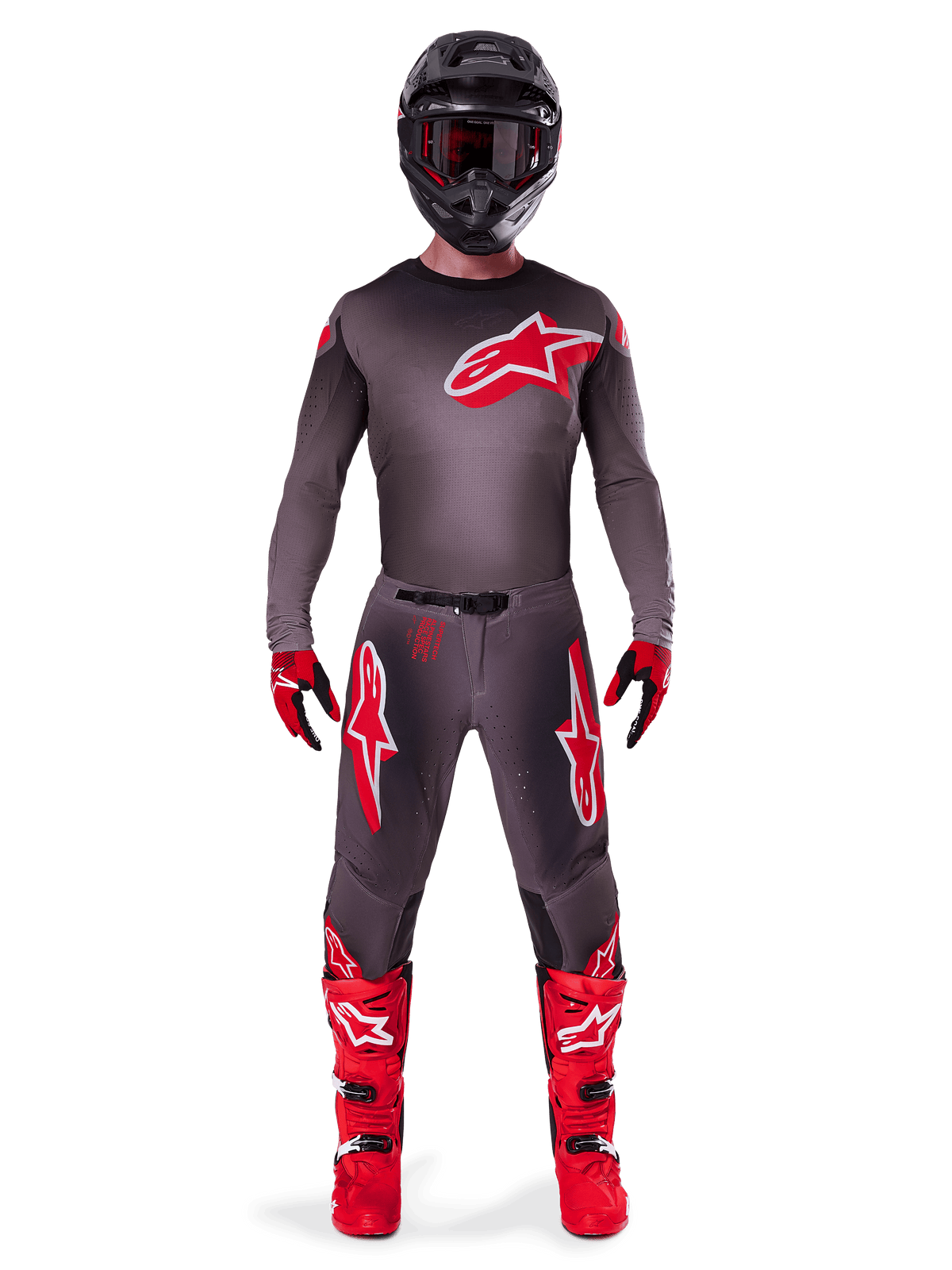 Pilota di motocross che indossa il set completo Alpinestars 2025 Supertech Lipan, Smoke Bright Red, caratterizzato da maglia e pantaloni grigio scuro con loghi rossi, casco nero con occhiali, guanti rossi e neri e stivali da motocross rosso vivace, outfit da gara professionale coordinato