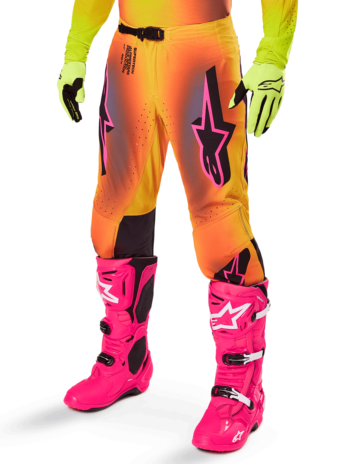 Alpinestars 2025 Supertech Lipan Gear Set, pantaloni da motocross, sfumatura giallo e arancione con accenti rosa e viola, con vistosi loghi Alpinestars neri sulle cosce, indossati con guanti gialli e stivali da motocross rosa acceso.