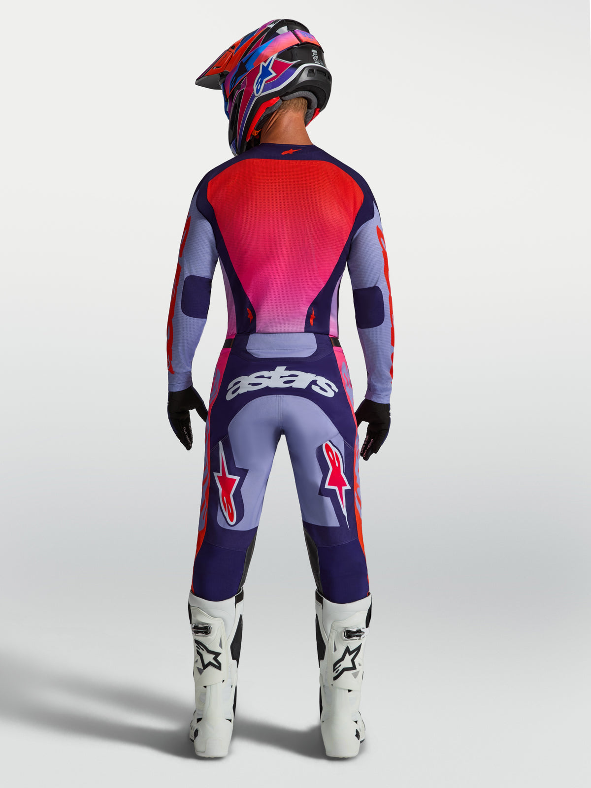 Alpinestars Pantaloni Racer Air Hunt, pantaloni da motocross viola e rosa su modello vista posteriore, design ventilato con logo Astars, abbigliamento racing off-road