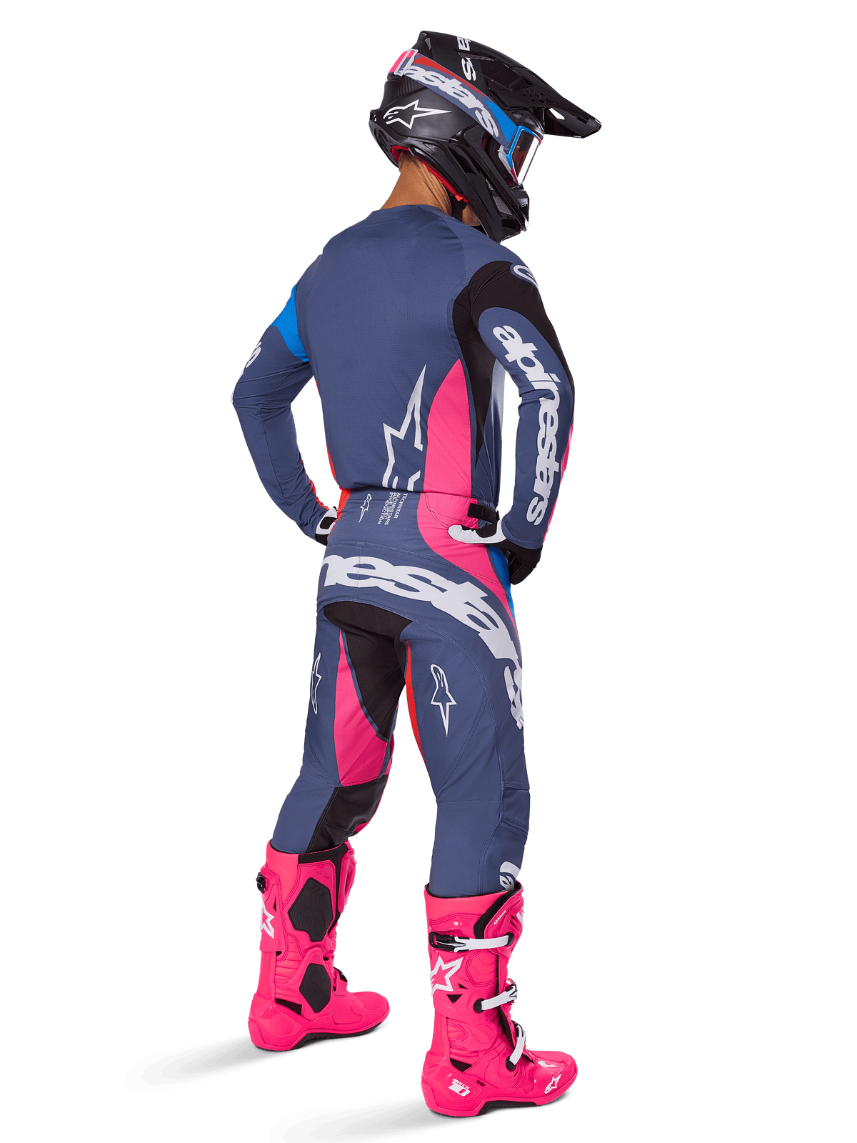 Pilota di motocross visto da dietro, pantaloni Alpinestars 2025 Techstar Dreem, design grigio-blu e rosa magenta con dettagli neri, indossati con maglia coordinata e stivali rosa vivace, vestibilità atletica da gara per prestazioni fuoristrada.