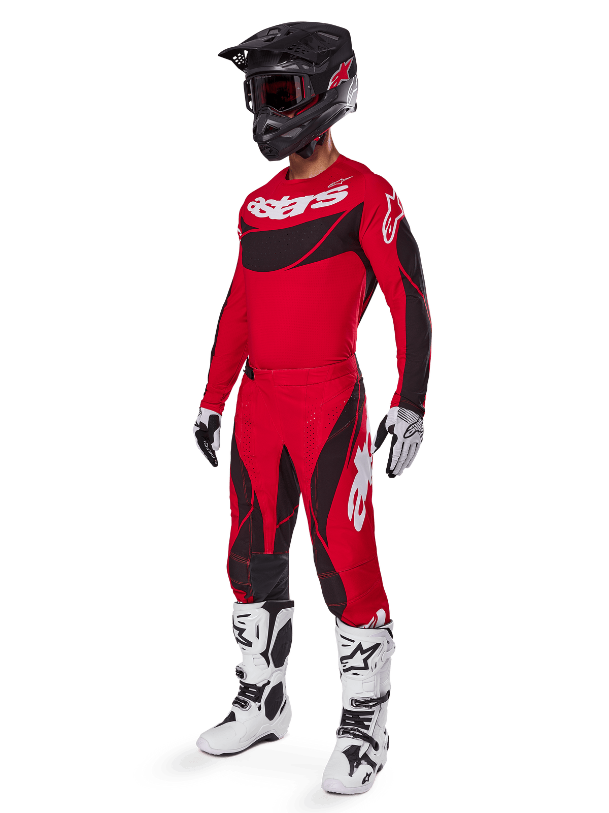 Pilota di motocross con abbigliamento completo da gara Alpinestars, pantaloni 2025 Techstar Dreem in rosso acceso e nero, maglia coordinata rossa e nera con logo bianco, casco nero e stivali bianchi e neri, outfit coordinato per corse fuoristrada