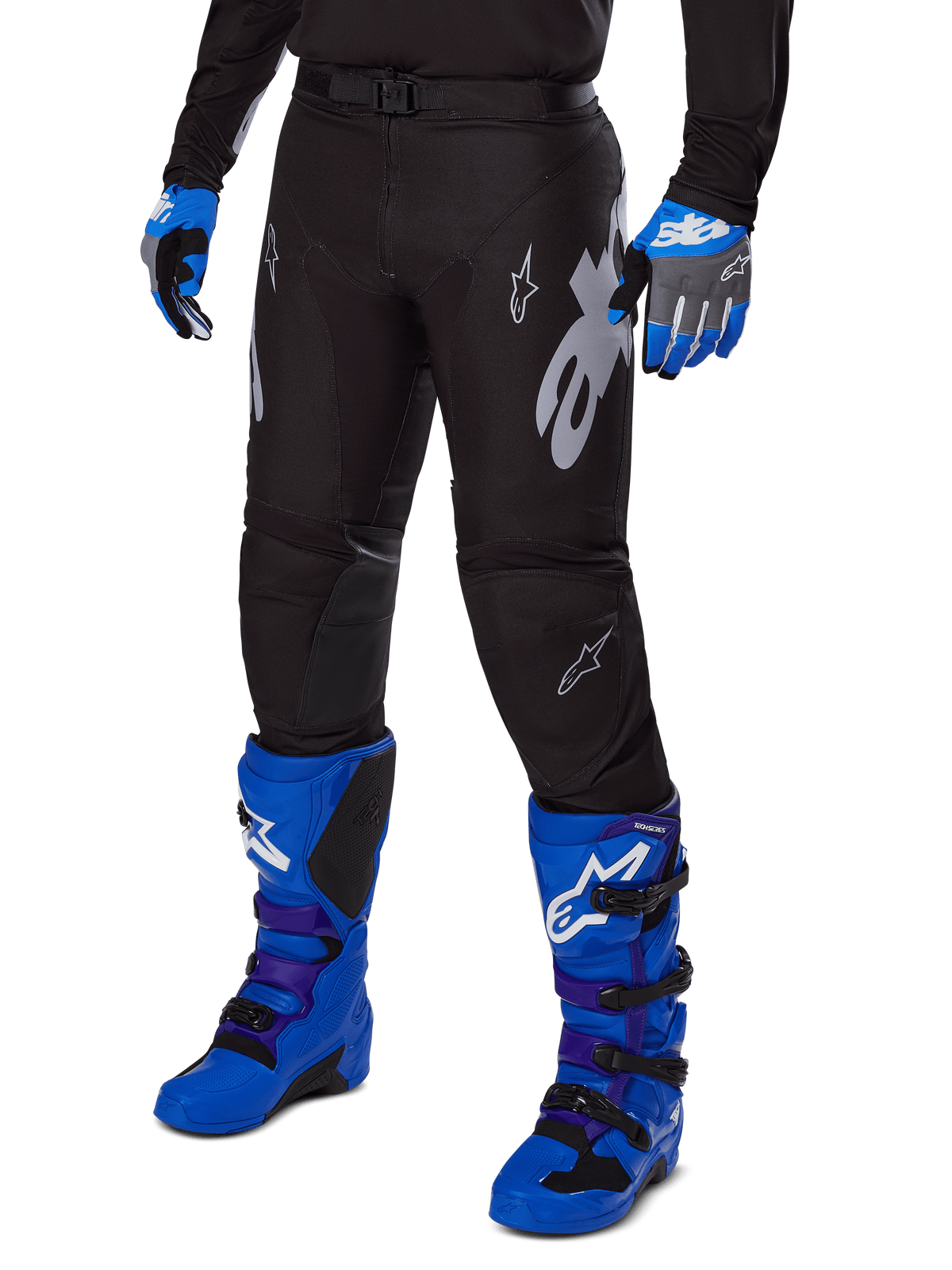 Alpinestars Pantaloni Racer Graphite 2025, pantaloni da motocross neri con grafiche bianche e grigie, indossati con stivali da motocross blu acceso e guanti blu coordinati, tessuto tecnico resistente per il fuoristrada