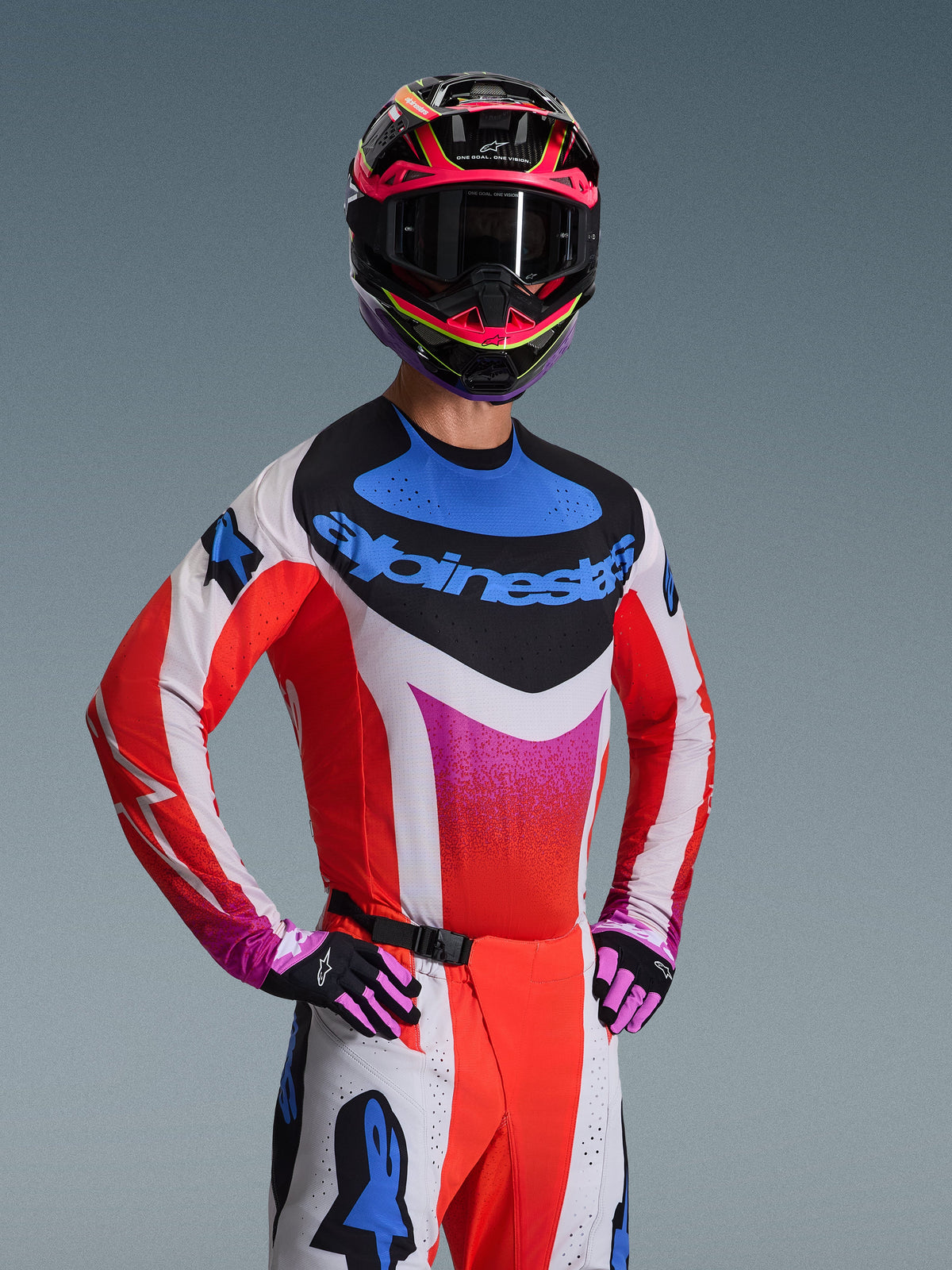 Set completo Alpinestars Techstar Knif 2026, abbigliamento da motocross, maglia bianca e rossa con sfumatura rosa e dettagli blu, pantaloni bianchi e rossi coordinati, casco rosa e nero con maschera scura, guanti neri e rosa, outfit coordinato per prestazioni off-road