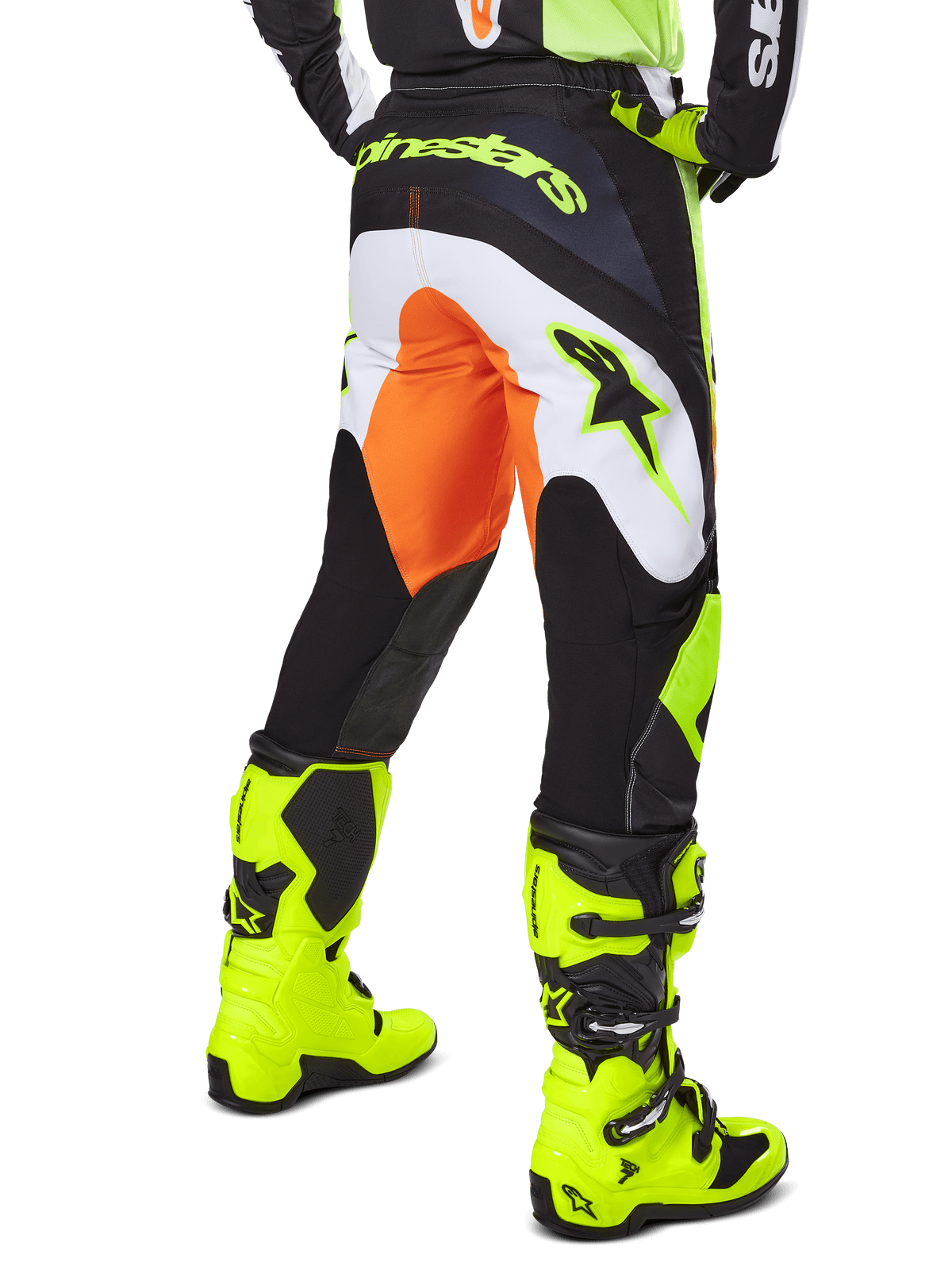 Alpinestars Pantaloni Fluid Wurx 2025, pantaloni da motocross, giallo e nero con dettagli arancioni e bianchi, vista posteriore indossati con stivali giallo brillante coordinati, design resistente per fuoristrada