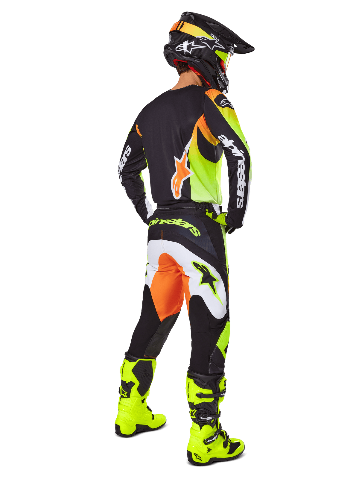 Pilota di motocross visto da dietro che indossa il set Alpinestars 2025 Fluid Wurx, maglia nera con accenti gialli e arancioni, pantaloni neri coordinati con inserti bianchi e arancioni, stivali giallo acceso e casco nero, abbigliamento completo da gara off-road