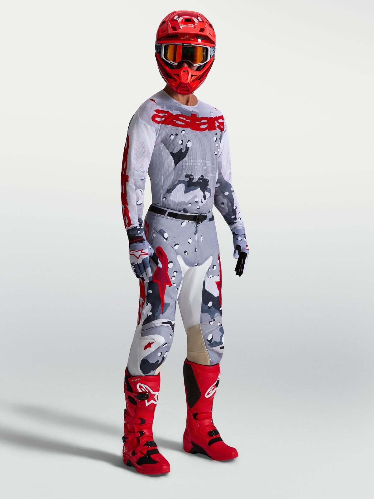 Alpinestars Pantaloni Racer Air Lone e maglia, completo da motocross da uomo grigio camo e rosso con stivali rossi coordinati, abbigliamento tecnico traspirante per fuoristrada.