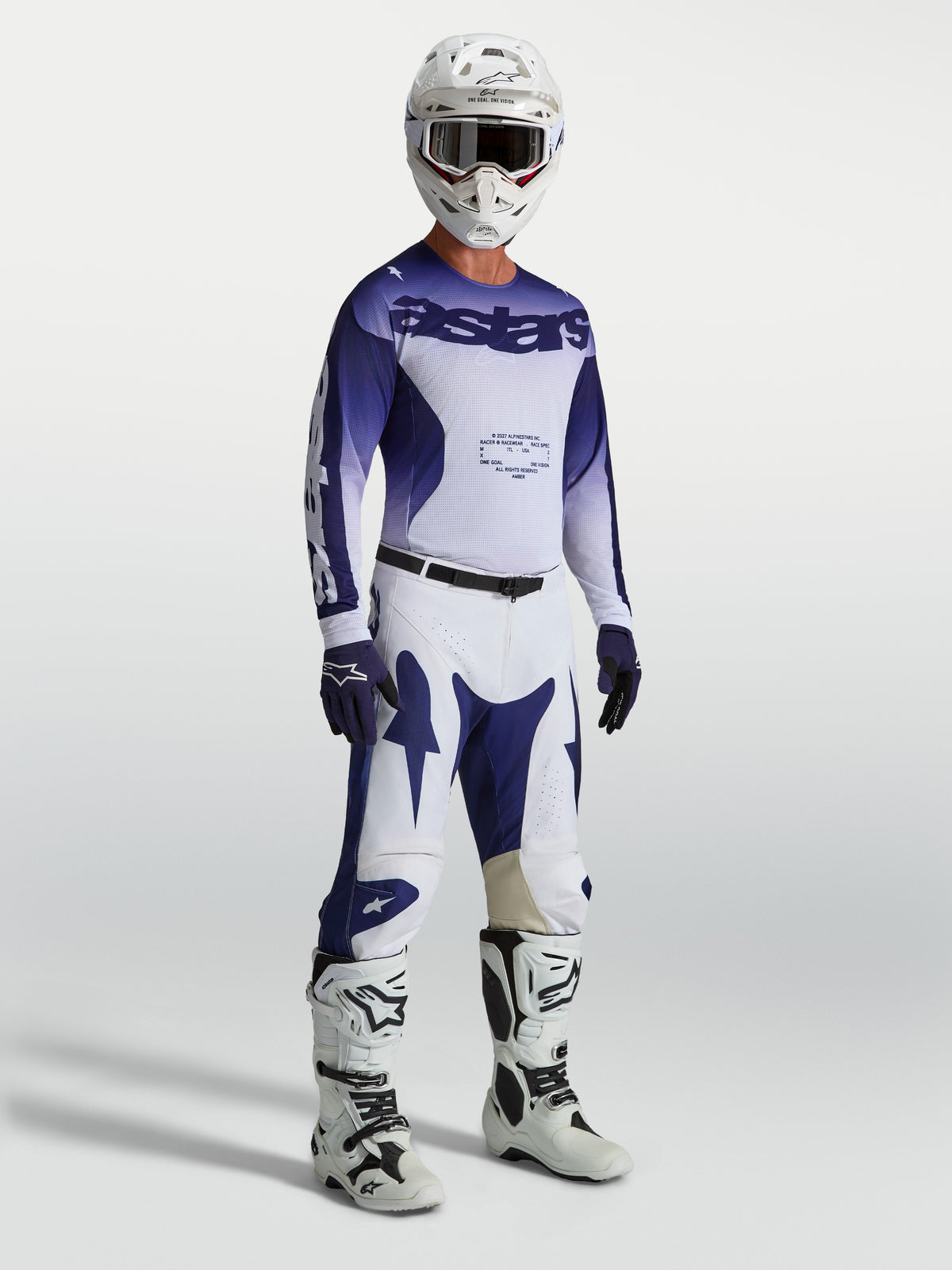 Alpinestars Pantaloni Racer Air Amber, pantaloni MX da uomo blu e bianchi su modello con maglia, stivali e casco coordinati.