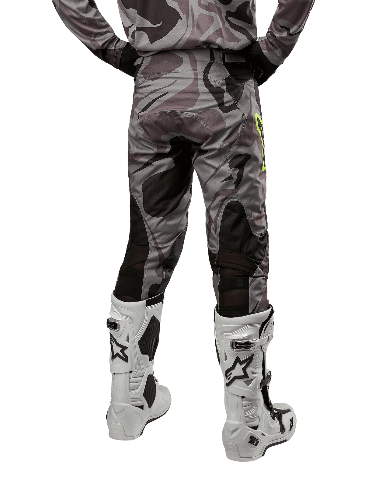 Alpinestars 2024 Racer Tactical Pants, pantaloni da motocross, Cast Gray Camo Magnet, vista posteriore con motivo mimetico e zone elasticizzate traspiranti nere, indossati con stivali da motocross bianchi e neri, progettati per il racing fuoristrada.