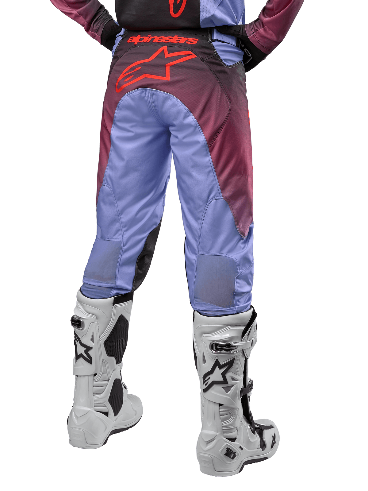 Alpinestars Racer Hoen Pants 2024, pantaloni da motocross, viola Lavan e nero, vista posteriore con grande logo a stella rosso sulla seduta, indossati con stivali da motocross bianchi, con pannelli elasticizzati traspiranti nella parte inferiore delle gambe