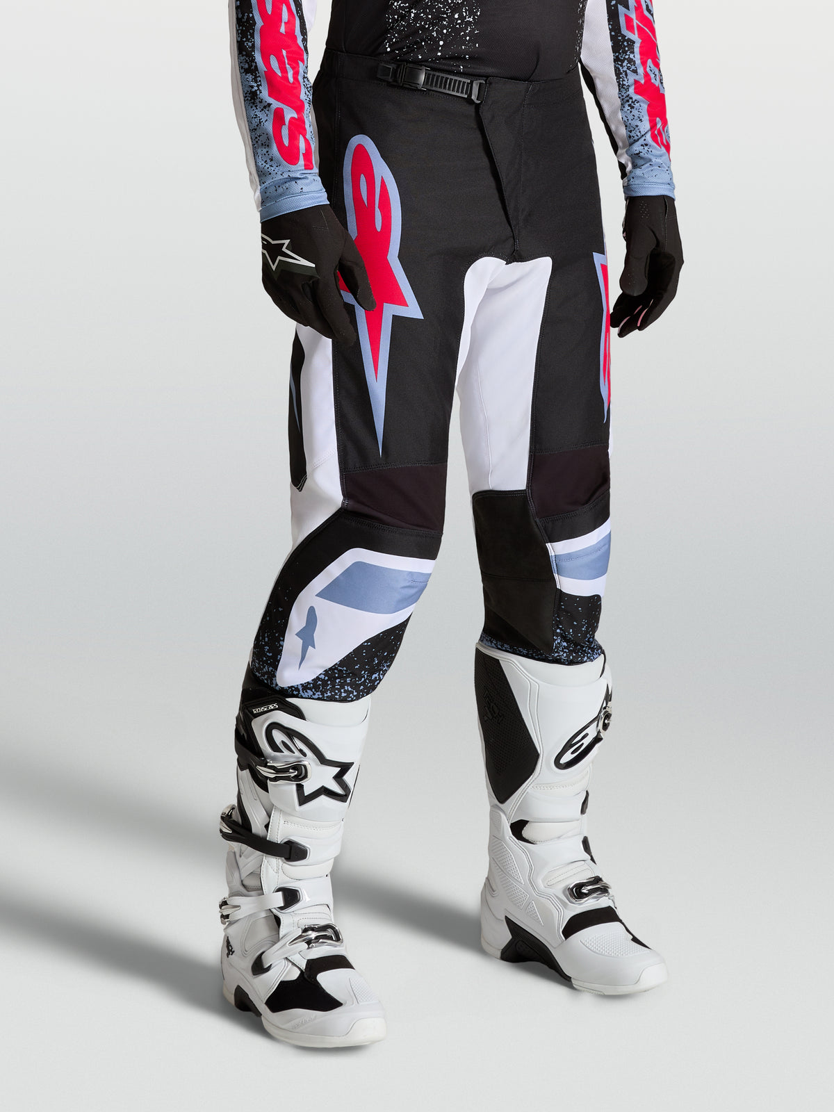 Alpinestars pantaloni Fluid Drag, pantaloni da motocross per uomo neri e bianchi con accenti rosso fluo e azzurro, per guida off-road.