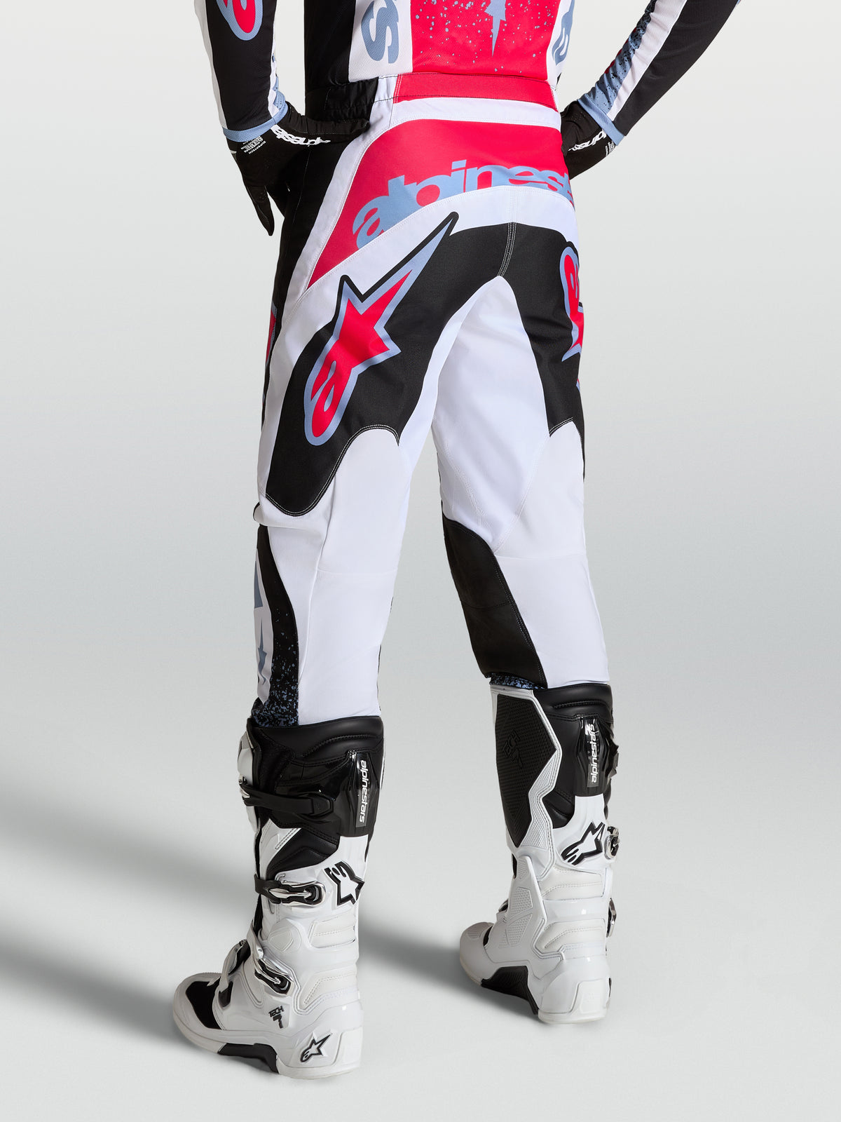 Alpinestars pantaloni Fluid Drag, pantaloni da motocross da uomo bianchi e neri con dettagli rossi e blu, vista posteriore.