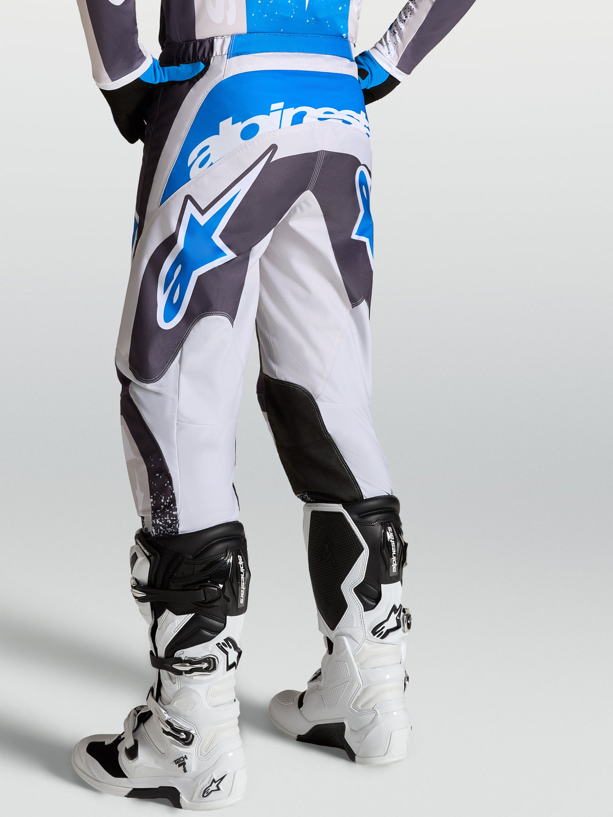 Alpinestars pantaloni Fluid Drag da uomo grigi e blu, vista posteriore con costruzione ergonomica 3D.