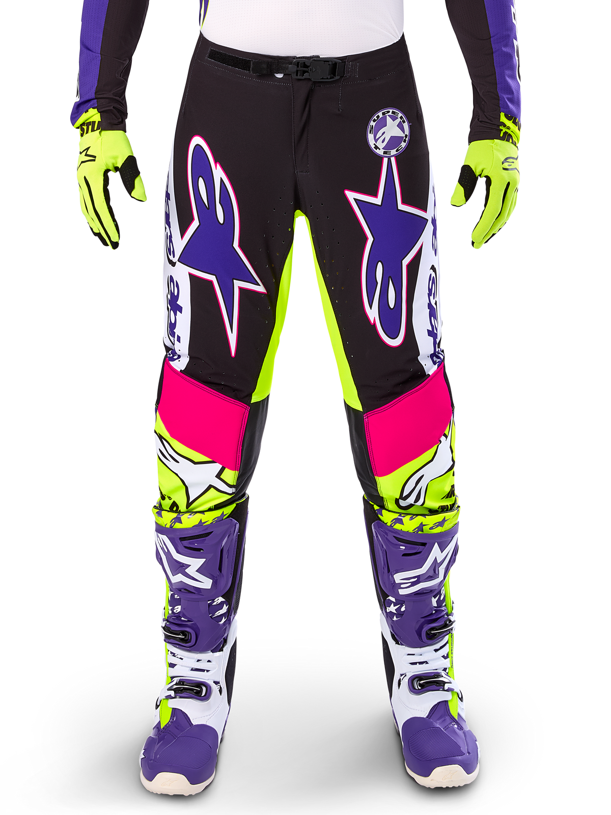 Alpinestars Limited Edition Supertech Dirt Studios Pants, pantaloni da motocross, bianco, viola e giallo fluo, con pannelli neri e accenti giallo neon e rosa, grandi loghi a stella viola, mostrati con guanti giallo neon e stivali da corsa viola coordinati, abbigliamento da corsa fuoristrada resistente
