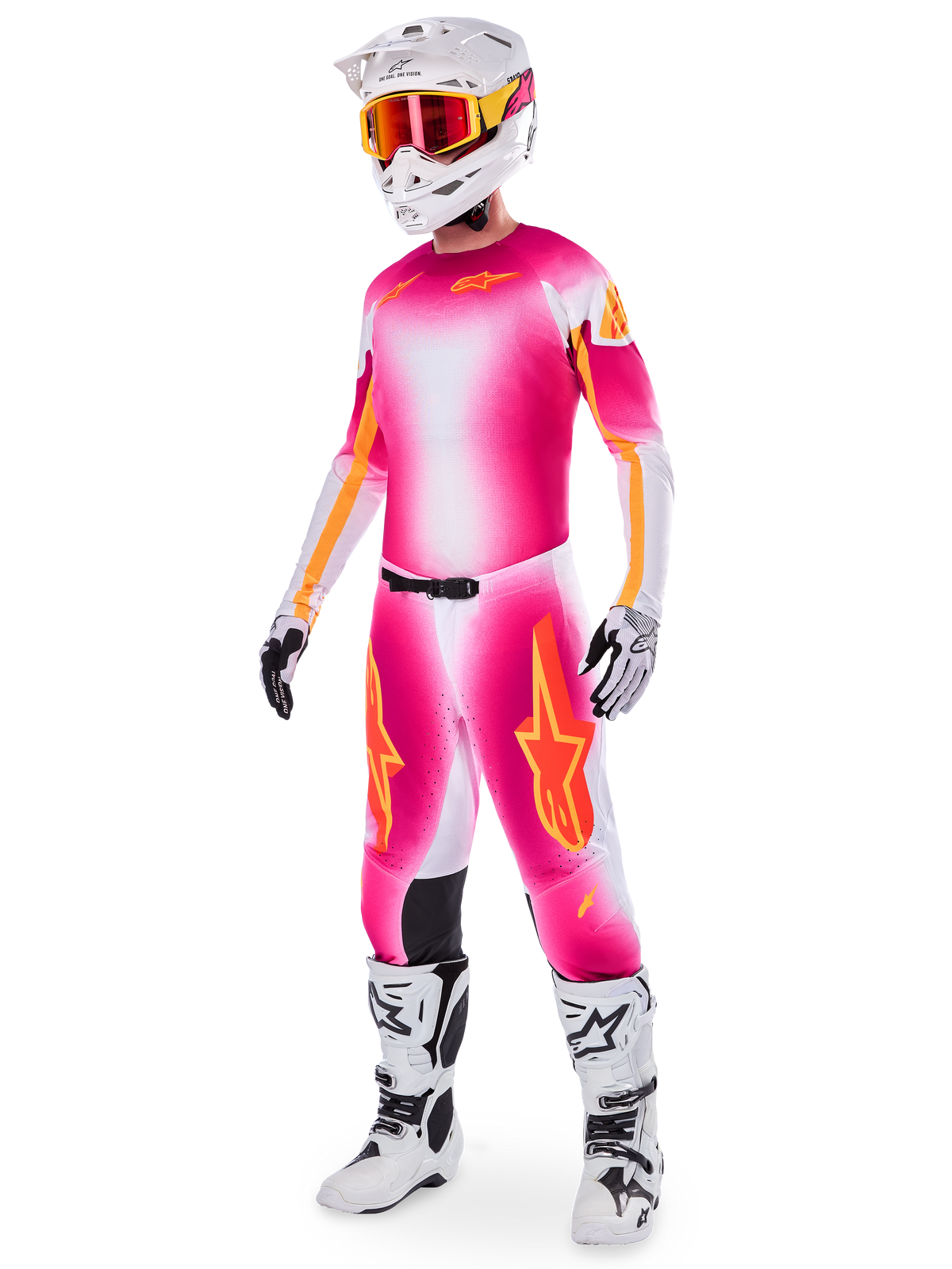 Pilota di motocross con set completo Alpinestars Supertech AFD MIG Limited Edition, maglia e pantaloni con sfumatura rosa fluo, bianco e arancione, casco bianco con occhiali arancioni, stivali bianchi e neri, abbigliamento professionale da fuoristrada