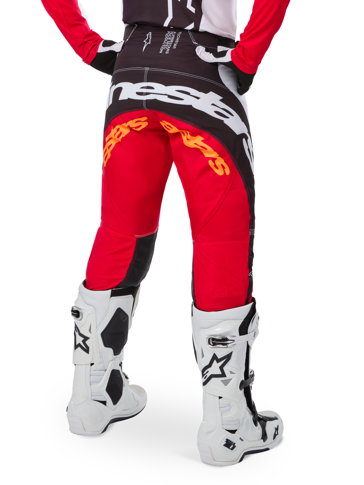 Alpinestars Techstar Deep Pants Edizione Limitata, pantaloni da motocross, nero, bianco e rosso acceso, vista posteriore con grande logo Alpinestars bianco sulla seduta e dettagli arancioni, indossati con stivali tecnici bianchi per competizioni fuoristrada professionistiche.