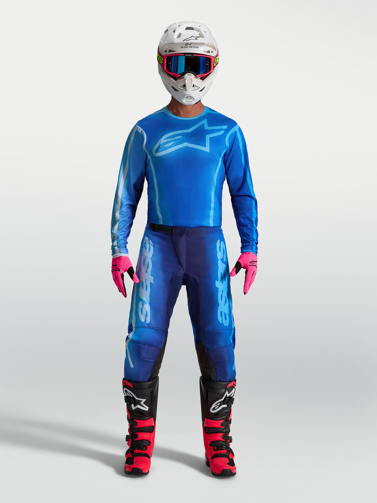 Alpinestars Pantaloni Fluid Kepler, pantaloni da motocross da uomo, blu, in poliestere 600D resistente e pannelli elasticizzati, indossati con casco e stivali da fuoristrada.