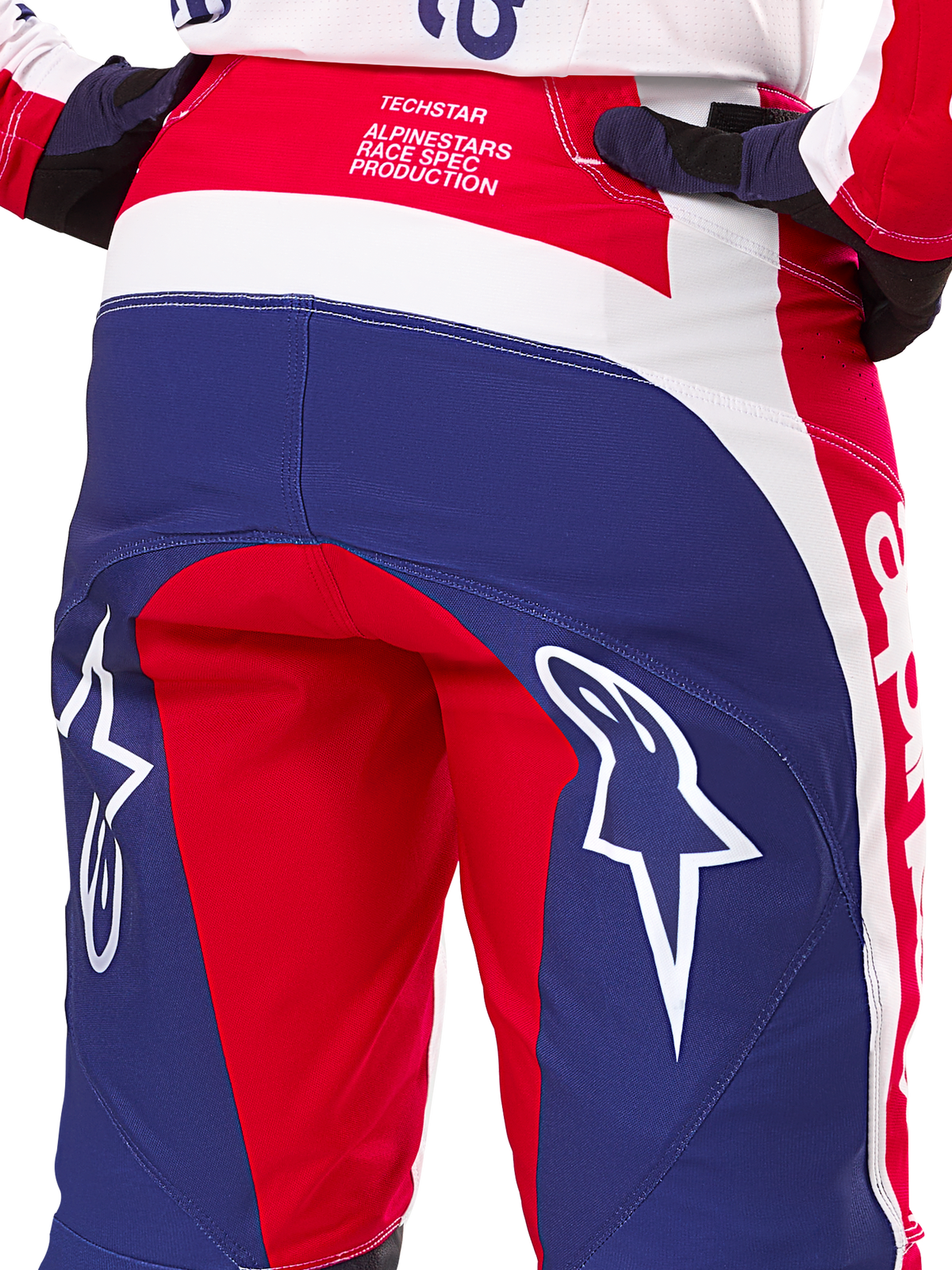 Pantaloni Alpinestars Limited Edition Techstar Fortitude, pantaloni da motocross, rosso, bianco e blu, vista posteriore con grandi loghi a stella bianchi sulla seduta e marchio Techstar Race Spec, tessuti tecnici resistenti per gare fuoristrada