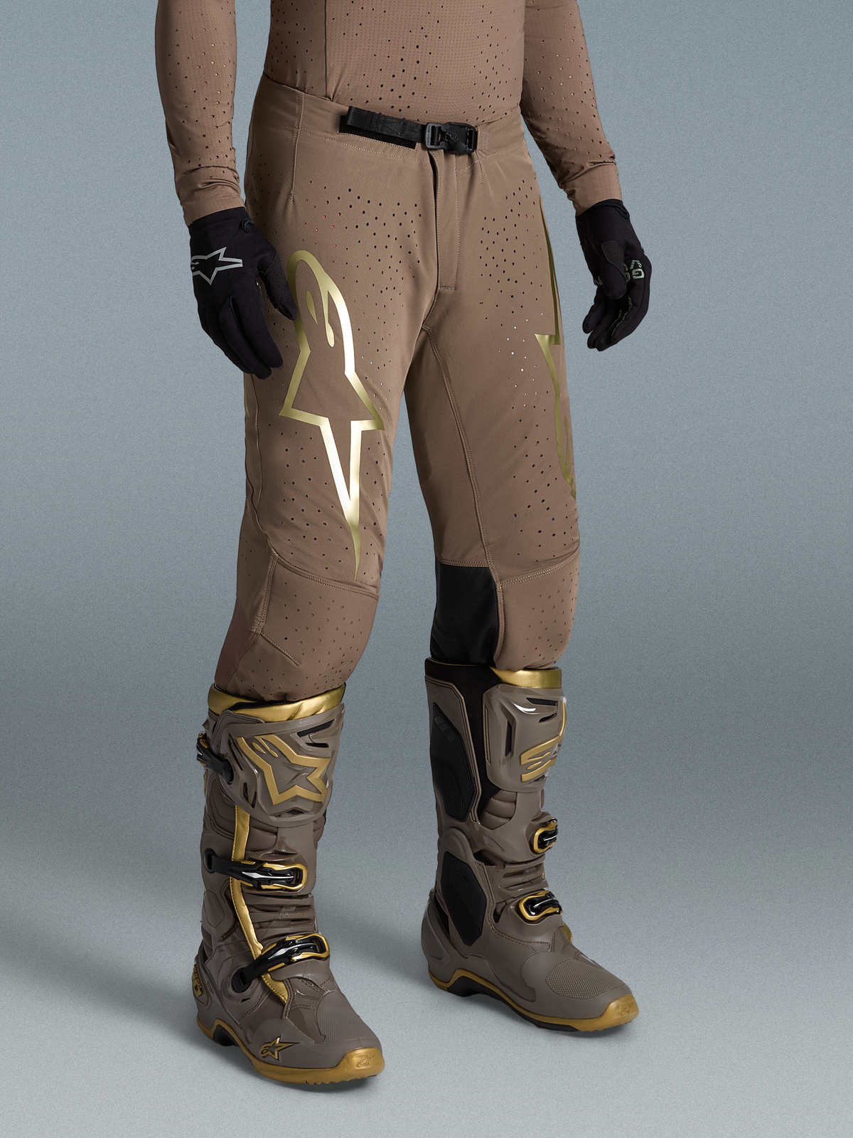 Alpinestars Pantaloni Supertech Air Gold Edizione Limitata, pantaloni da motocross per uomo, marrone e oro, in tessuto stretch perforato, indossati con stivali Tech 10 coordinati