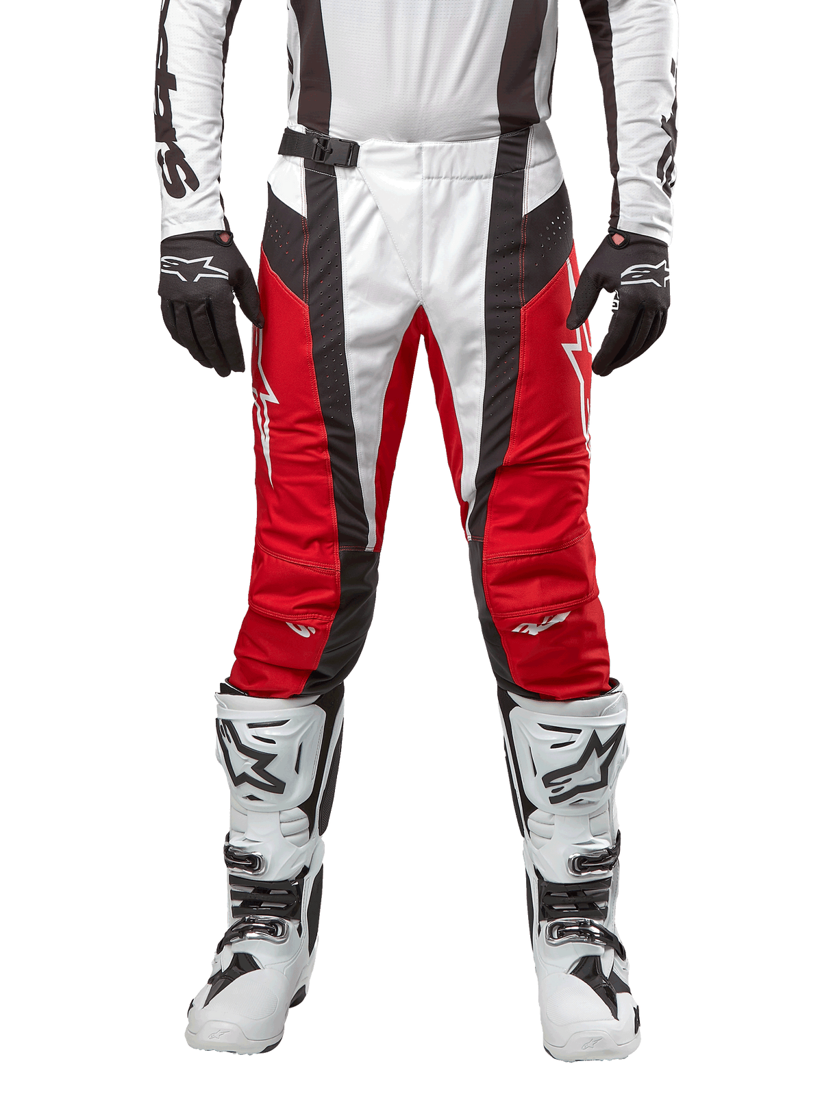 Alpinestars Techstar Ocuri Pants 2024, pantaloni da motocross, rosso Mars, bianco e nero, vista frontale indossati con maglia bianca coordinata, guanti neri e stivali bianchi, caratterizzati da pannelli traforati traspiranti e un taglio d'ispirazione racing per prestazioni fuoristrada.