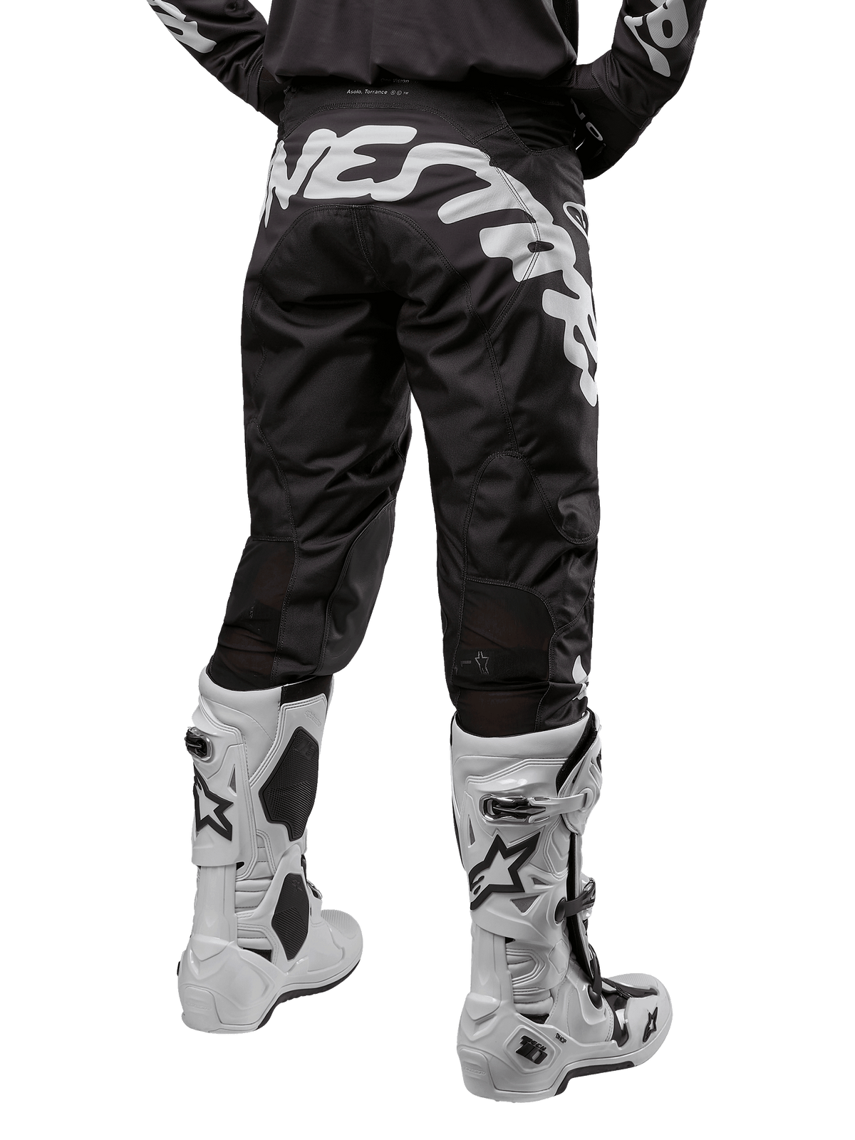 Alpinestars 2024 Racer Hana Pants, pantaloni da motocross nero e bianco, vista posteriore con grande logo Alpinestars bianco, abbinati a stivali tecnici bianchi, equipaggiamento per fuoristrada
