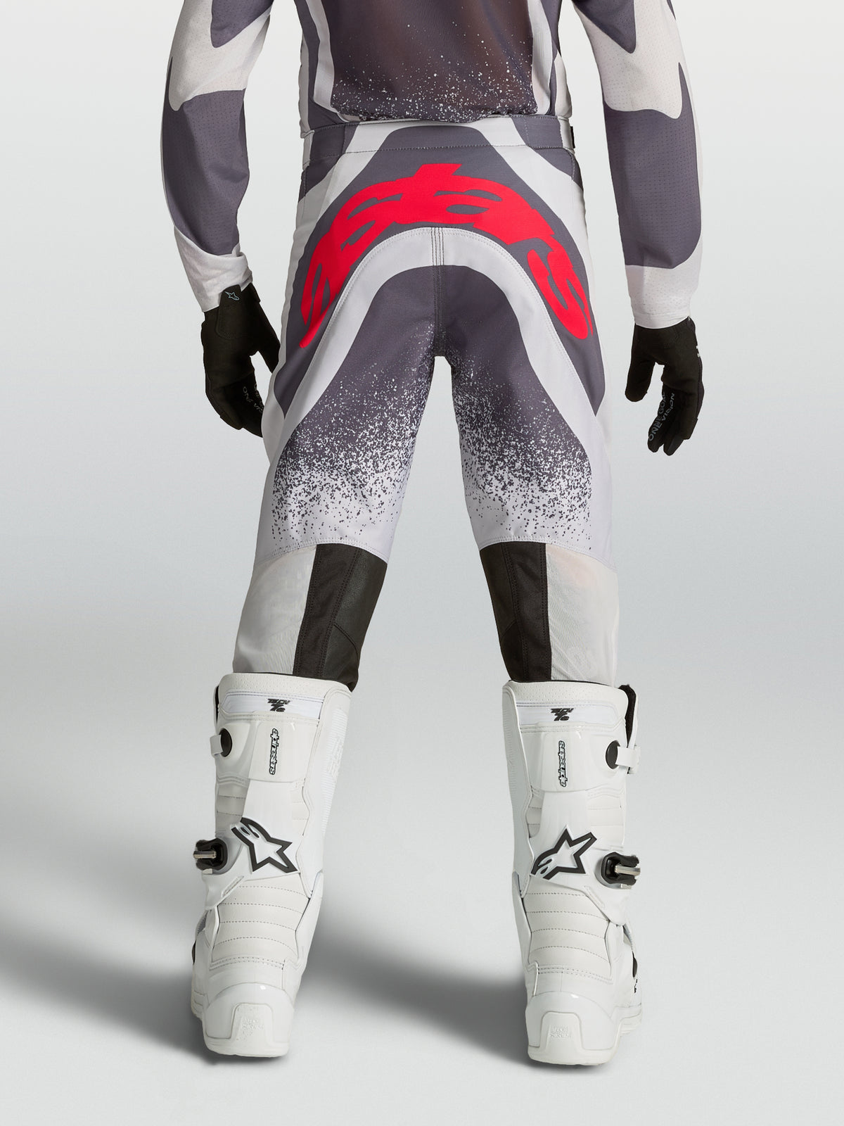 Alpinestars Pantaloni Supertech Swan Ragazzo, pantaloni motocross grigi e rosso fluo, vista posteriore atletica