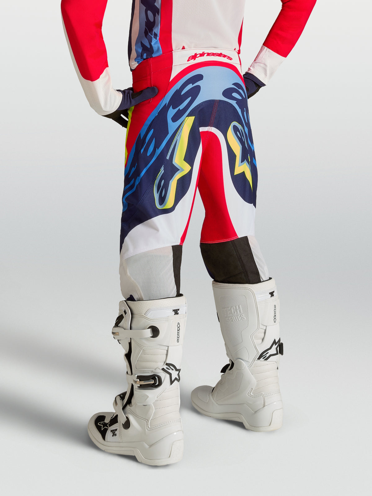 Alpinestars Pantaloni Supertech Dyna Ragazzo, pantaloni da motocross rosso fuoco e blu navy per giovani piloti, vista posteriore.