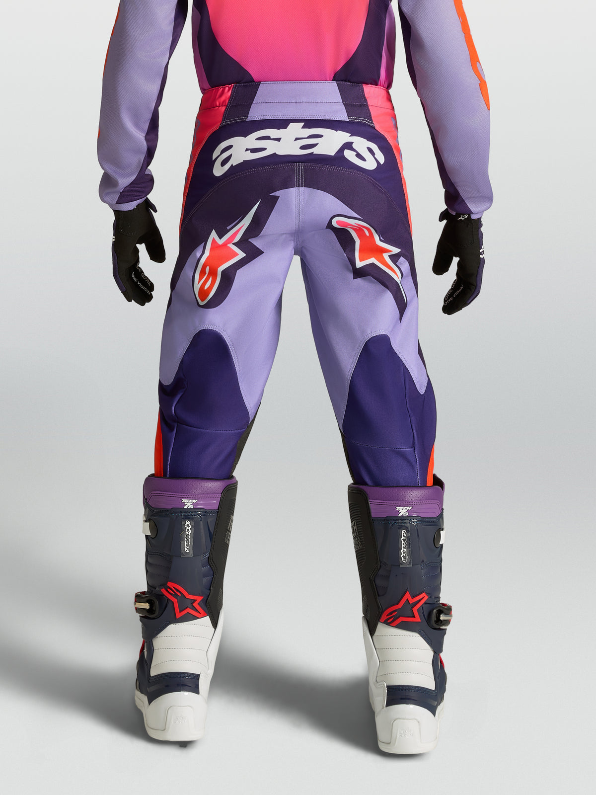 Alpinestars Pantaloni Fluid Hunt Ragazzo, pantaloni da motocross fuoristrada, viola e rosa, loghi a stella rossi e scritta astars bianca, costruzione in poliestere resistente, vista posteriore su modello.