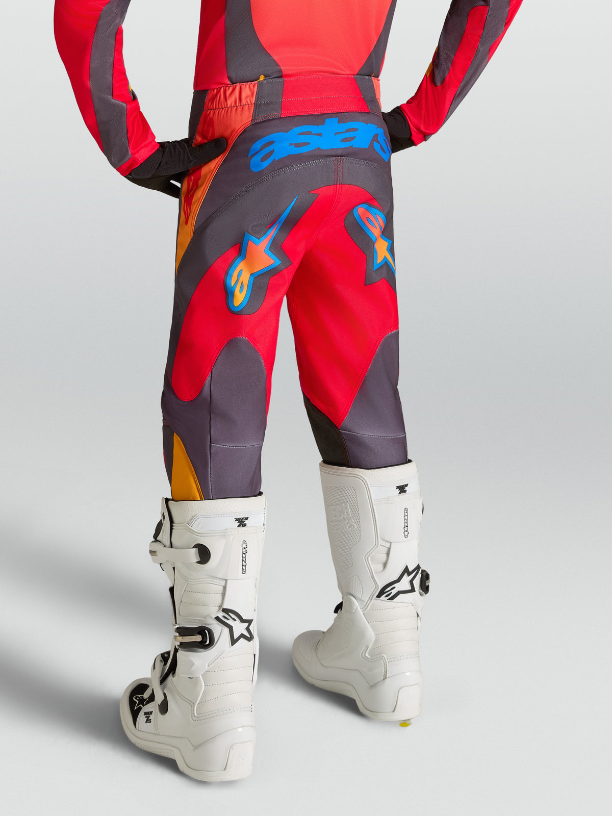 Alpinestars Pantaloni Fluid Hunt Ragazzo, pantaloni da motocross per ragazzi, rosso e grigio, poliestere 600D, vista posteriore con loghi grafici blu e arancioni