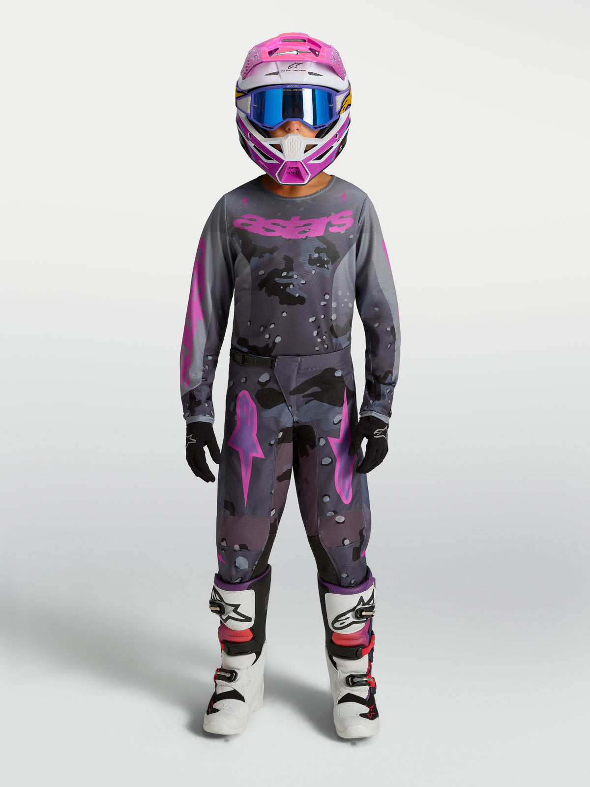 Alpinestars Pantaloni Fluid Lone Ragazzo, pantaloni da motocross in grigio camo e viola, in polifabric 600D con design 3D, indossati da un giovane pilota per performance off-road.