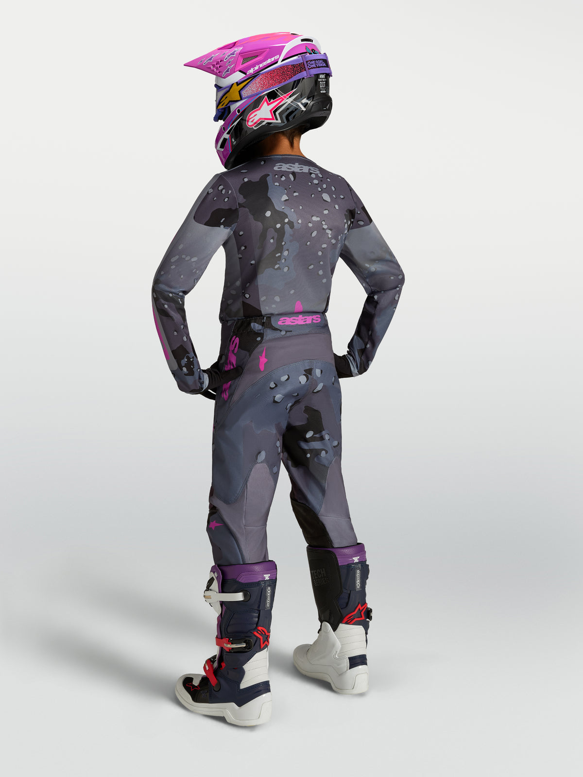 Alpinestars Pantaloni Fluid Lone Ragazzo, pantaloni da motocross e fuoristrada per giovani piloti, colore grigio camo e viola, indossati con kit completo da racing MX, design ergonomico e resistente.