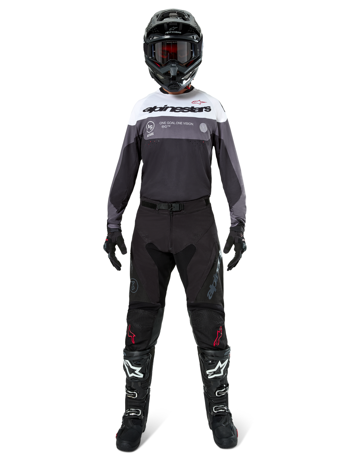 Pilota di motocross con equipaggiamento da gara completo, maglia Pro-Dura in Black Magnet White con parte superiore del petto bianca e dettagli grigi, abbinata a pantaloni neri, casco nero con maschera scura, stivali bianchi e neri e guanti neri, outfit coordinato per enduro e fuoristrada