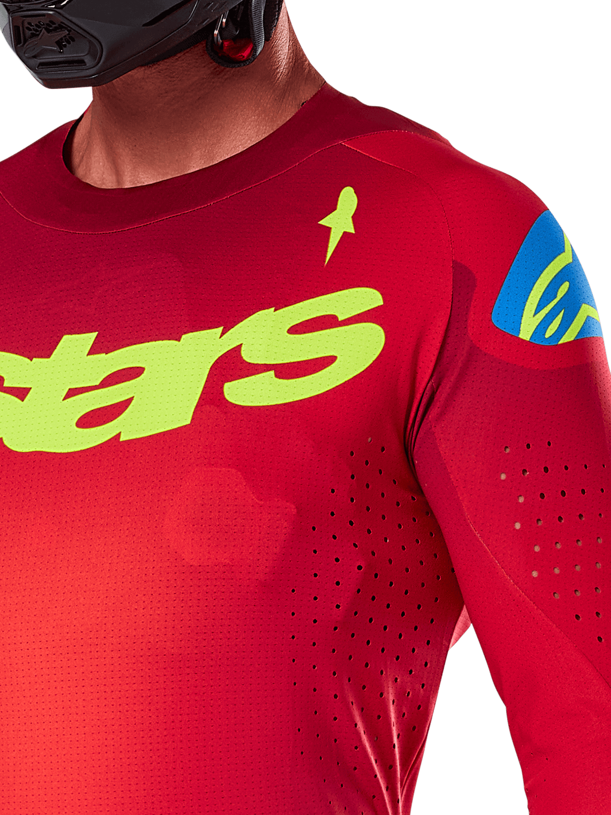Alpinestars 2025 Supertech Maker Jersey, maglia da motocross, rosso acceso e giallo fluo, vista ravvicinata con perforazioni tagliate al laser, marchio Alpinestars giallo sul petto, dettaglio blu sulla spalla, tessuto a rete elasticizzato traspirante