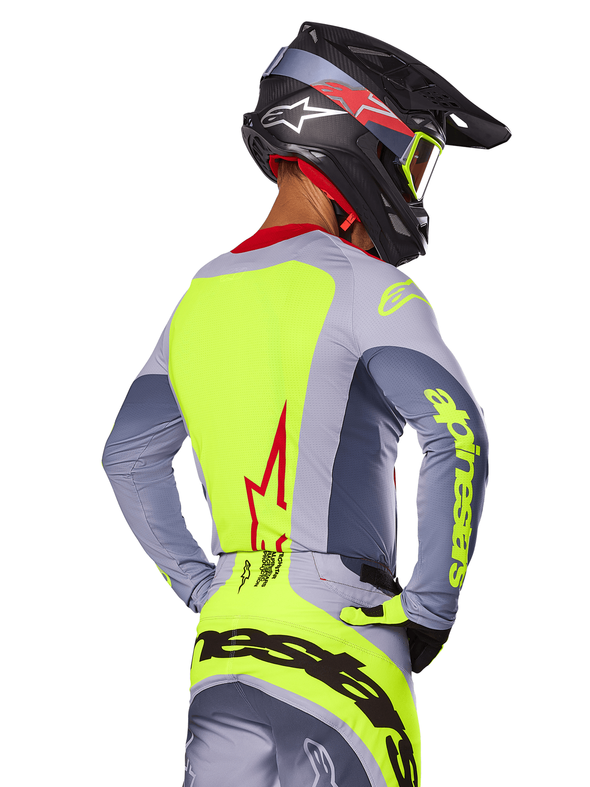Alpinestars 2025 Techstar Melt Jersey, Bright Red Gray, vista posteriore di un pilota di motocross con abbigliamento da gara grigio e giallo neon, logo a stella rossa sulla schiena, casco coordinato nero e rosso, abbigliamento tecnico per fuoristrada