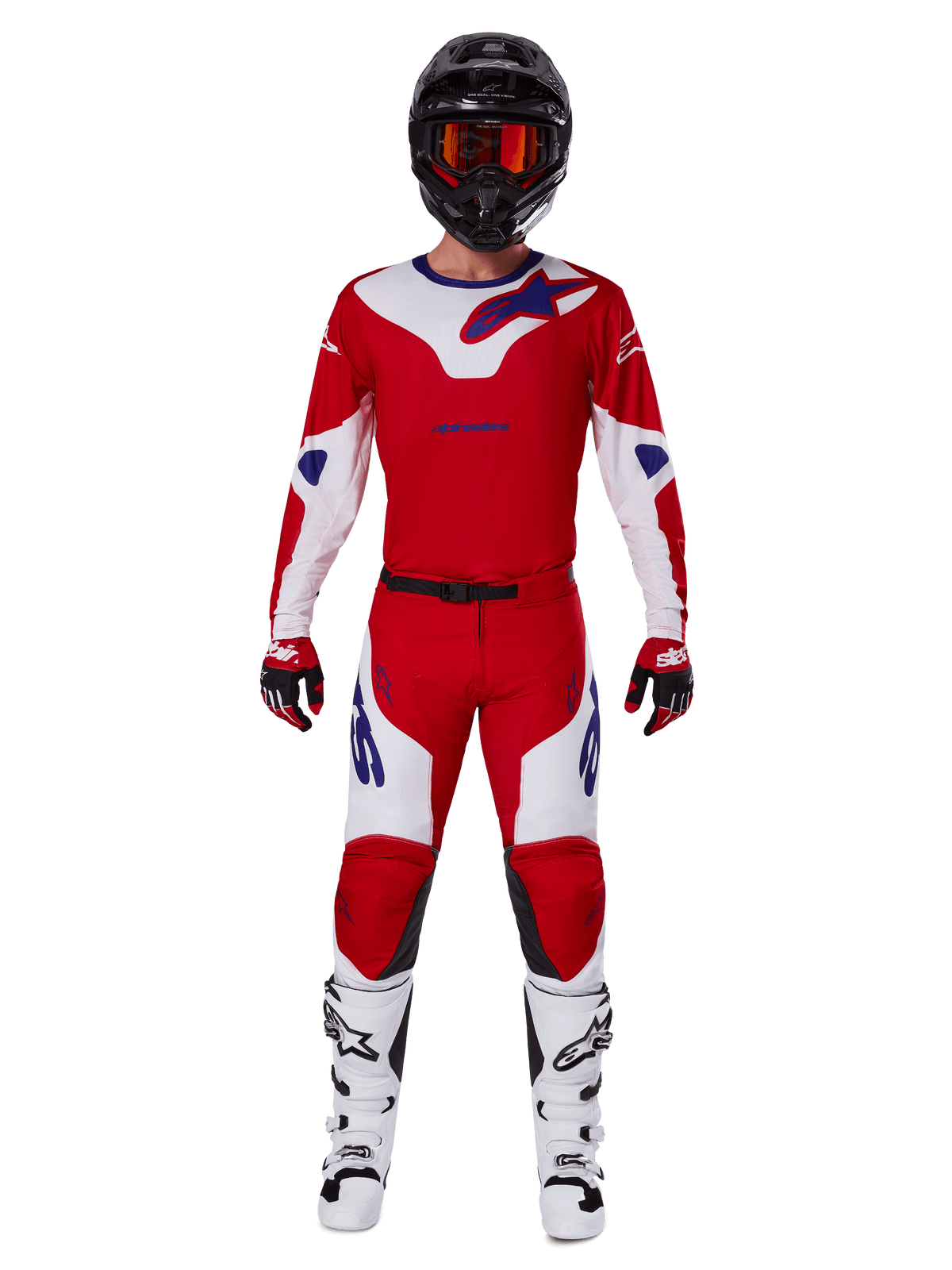 Pilota di motocross che indossa il set Alpinestars Racer Veil 2025, maglia e pantaloni rosso acceso e bianco con dettagli blu, casco nero con occhiali rossi, stivali bianchi e guanti rossi e neri, outfit coordinato per gare fuoristrada